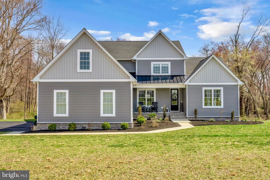 Discover an exquisite blend of modern luxury and serene living in this stunning home nestled within the prestigious Willow Branch East community. Built in 2022, this exceptional home boasts 3,011 square feet of meticulously designed space, offering an unparalleled lifestyle for those who appreciate the finer things in life. There is also approximately 1478sf of unfinished basement. Step inside to find an open floor plan that seamlessly integrates the living, dining, and kitchen areas, creating an inviting atmosphere perfect for both entertaining and everyday living. The gourmet kitchen is a chef's dream, featuring high-end stainless steel appliances, including a built-in microwave, down-draft cooktop, and wall oven, all complemented by a spacious island and ample table space. The elegant dining area and formal dining/office room provide the perfect backdrop for memorable gatherings. The heart of the home is the family room, where a stunning gas fireplace with glass doors and a stylish mantel creates a warm and inviting focal point. Recessed lighting and ceiling fans enhance the ambiance, while luxury vinyl plank flooring adds a touch of sophistication throughout. This residence offers four generously sized bedrooms, including a main-level bedroom for convenience. The primary suite is a true retreat, featuring a lavish en-suite bathroom and expansive walk-in closets. Step outside to your own personal oasis, where a spacious deck overlooks a beautiful yard that backs to tranquil trees, providing a serene escape from the hustle and bustle of daily life. The 1.42-acre lot offers ample space for outdoor activities and gatherings, while the attached side-entry garage and asphalt driveway provide convenience and curb appeal. Additional highlights include a main-floor laundry room, a tankless water heater for endless hot water, and an unfinished walkout basement with a Sauna and endless potential for customization. Enjoy relaxing in the outdoor Hot Tub located just steps away from the Sauna. This home is not just a residence; it's a lifestyle choice that embodies luxury, comfort, and tranquility. Also included are 6 wall mounted TV’s, Sauna, Hot Tub and a one year home warranty.  Easy commute to DC, the Western Shore and the Eastern Shore beaches.