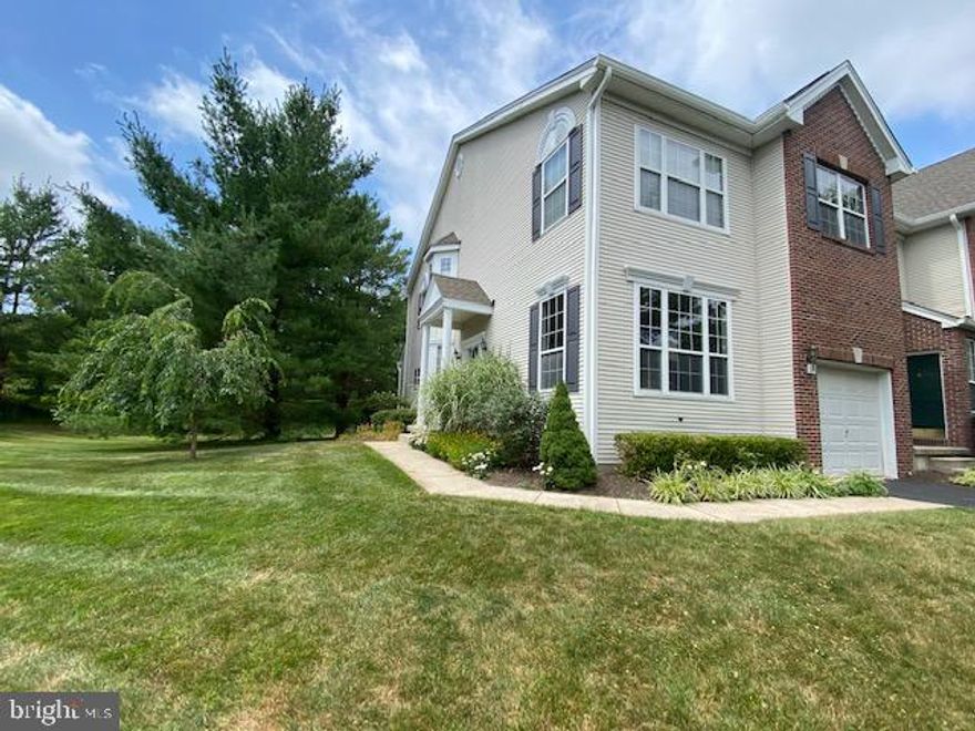 Welcome to this exceptional end-unit townhome in the prestigious community of Heritage Hills in Washington Crossing, PA. Perfectly situated on one of the most desirable lots in the neighborhood, this home backs to mature trees and offers rare side privacy, creating a peaceful setting seldom found in townhome living.  Enter through the private side entrance into a welcoming foyer with ceramic tile flooring. Gleaming hardwood floors span the Living Room, Dining Room, and Family Room, while 9-foot ceilings enhance the light and openness of the main level. The dramatic two-story Family Room is centered around a  fireplace and a striking wall of windows overlooking the private rear yard. Memories are made here! The updated Custom Gourmet Kitchen is thoughtfully designed for both everyday living and entertaining. Features include 42-inch cabinetry with detailed moldings, Granite countertops with bar seating, Stainless Steel appliances, a slide-in range with hood, built-in wine cooler, wine rack, and a custom pantry. The adjacent Breakfast Area opens to a newer deck with awning, extending your living space outdoors. Whether enjoying a quiet morning coffee or an evening glass of wine, this setting delivers privacy and serenity. Upstairs, the expansive Primary Suite offers a true retreat with cathedral ceiling, ceiling fan, two walk-in closets with custom organizers and pocket doors, and a private bath featuring dual vanities, a deep soaking tub, separate ceramic tile shower, and ceramic tile flooring. The two additional generously sized bedrooms share a well-appointed hall bath. The full basement provides abundant storage and excellent potential for future finishing to your specifications. Additional highlights include a Newer Roof (2021), Newer HVAC system (2023), Newer 80 Gallon Hot Water Heater (2022), Newer Deck  with Newer Sliding Glass Door (2022), Newer Washer & Dryer (2020). Residents of Heritage Hills enjoy community amenities including an outdoor pool and tennis courts. Ideally located near I-95, Princeton, Philadelphia, and New York, and just minutes from Washington Crossing Historic Park and the Delaware Canal Towpath for walking, jogging, and biking. All within the highly acclaimed Council Rock School District! A rare opportunity to secure a prime lot in one of Upper Makefield’s most desirable communities.
