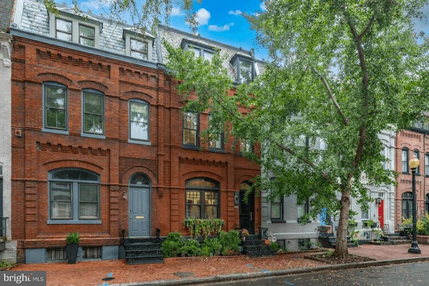 NEW PRICE - Originally built in 1885, this 5 bedroom, 3.5 bathroom rowhome was completely renovated in 2020 by Akseizer Residential.  Located on a beautiful tree-lined street, known to be DC’s most photographed street, this home is convenient to the vibrant Dupont, Logan and U Street hot spots. This special residence blends historic charm and character with modern luxury and high-end finishes. The main level features custom herringbone floors, an open living room with a gas fireplace and custom built-ins, and a spacious dining area. The chef's kitchen is a showstopper with Pietra black marble, high end appliances including a Wolf 6-burner range and a floor-to-ceiling wine refrigerator. A wall of rear windows provides loads of natural light for the breakfast nook overlooking the private courtyard/secure off-street parking. The second level offers a generous primary suite with a gas fireplace, custom built-ins and luxurious bath. Bedroom #2 opens to a private balcony. The third level includes two additional spacious bedrooms with custom closets, a full marble bathroom with brass fixtures and access to the upper roof decks with unobstructed views of the Scottish Rite Temple. The lower level has a media/recreation room with a built-in entertainment wall, a fifth bedroom, a full marble bathroom, and a well-appointed laundry room.  Easy to commute by foot or car to downtown DC, the White House, and several metro lines, this is city living at its finest!