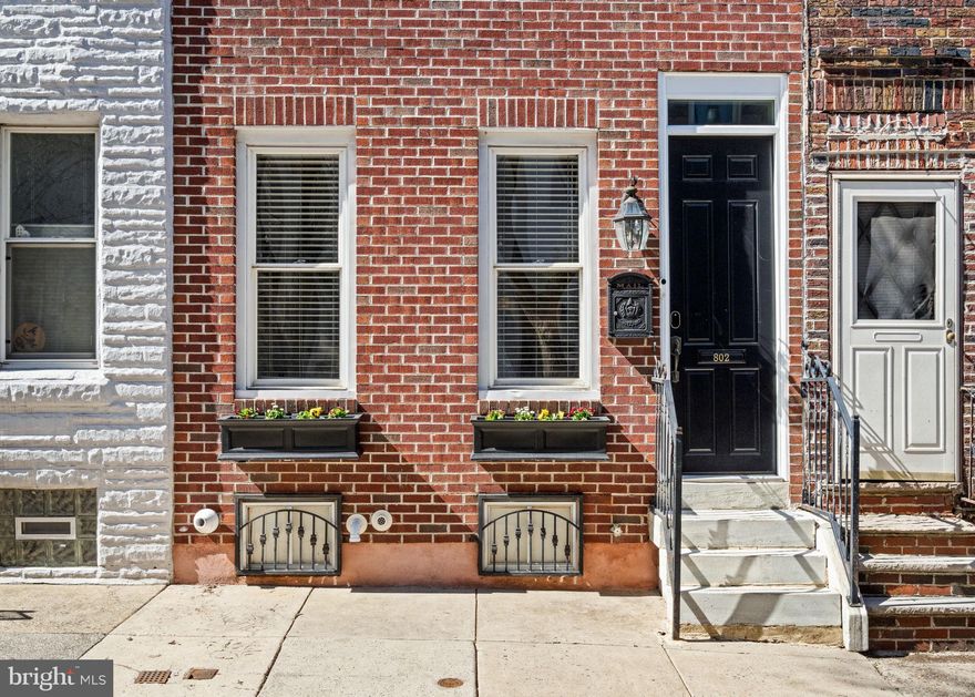 This classic Fairmount townhouse offers expanded living space with the addition of a newly constructed third-floor primary suite and roof deck. The first floor features an open living and dining area and original hardwood floors, detailed millwork, and exposed brick accents that flow into the kitchen with direct access to the private rear patio. The second level hosts three well-proportioned guest bedrooms and a full bath. Above, the newly added primary level creates a private retreat complete with a spacious bedroom, walk-in closet, full bath with marble finishes, and an adjacent den/office or nursery. The roof deck =captures skyline views, remarkable sunsets, and treetop views of Fairmount Park. The lower level is currently configured as a casual pub-style gathering space and offers flexible potential for additional living, recreation, or storage. Situated on a little block in Fairmount, 802 Bambrey Street combines classic townhouse character with all the conveniences of today.