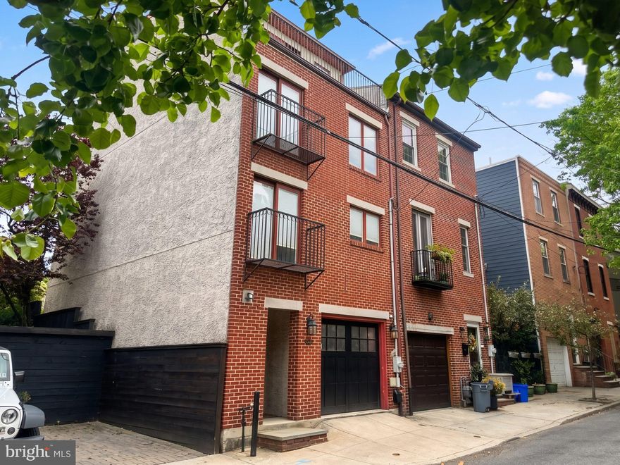 Discover a rare architectural gem that bridges the gap between high-end comfort and historic charm. Located on one of Northern Liberties’ most picturesque, tree-lined blocks, this semi-detached contemporary home offers the luxury and efficiency of a 2022 renovation while retaining a unique sense of place. Backing directly onto a lush community garden, the residence provides a private, verdant sanctuary that feels deeply rooted in the neighborhood's established character, offering a serene escape that is virtually impossible to find in standard new construction. The interior is defined by soaring 15-foot ceilings and an abundance of natural light streaming through premium Pella windows and doors. The heart of the home is a showstopping chef’s kitchen featuring a double waterfall quartz island and custom cabinetry, which overlooks an elegant formal living room anchored by a fireplace. The thoughtful floor plan scales beautifully across multiple levels, including a dedicated top-floor primary suite, a true retreat with a private office nook, dual balconies, and a spa-like ensuite with a jetted tub. Throughout the home, designer touches like imported wallpaper, California Closets, and engineered hardwoods elevate the aesthetic beyond the ordinary. Exceptional outdoor living and utility complete this luxury offering. Five distinct outdoor spaces include a redone backyard deck for seamless entertaining and dual rooftop decks that capture panoramic views of the Center City skyline and the Ben Franklin Bridge. The lower level provides a comfortable family room and guest suite, while the entry floor offers the rare city convenience of an attached garage. Situated just steps from the city's premier dining and transit, this home is a sophisticated sanctuary for the buyer who demands modern comfort within a classic Philadelphia context.