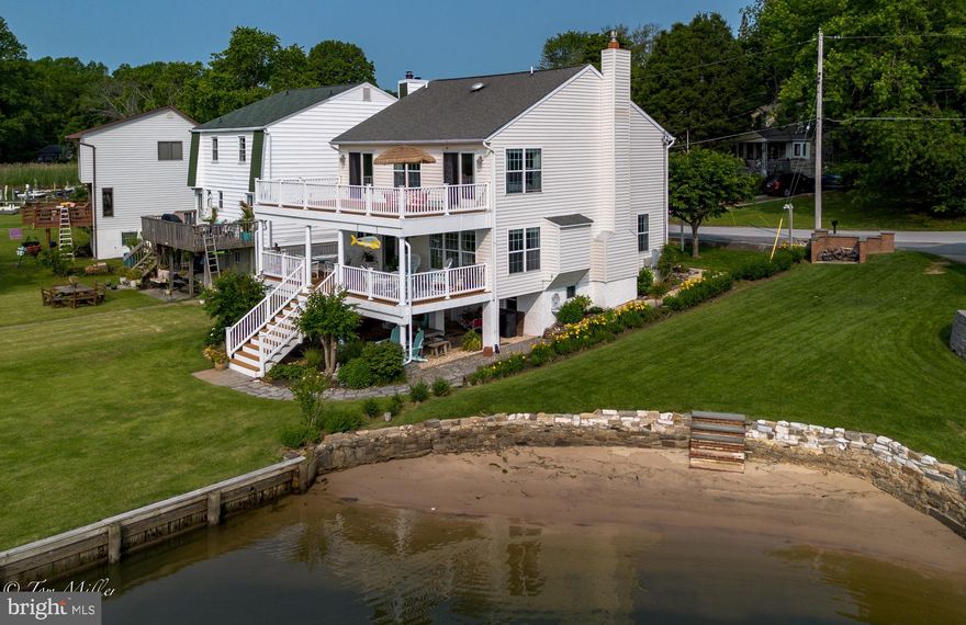 MILLION-DOLLAR  Views in Ba​u​ernschmidt Manor! 
This stunning waterfront property offers big, Eastern water views of Middle River and 6​3 feet of prime shoreline. Enjoy the coastal lifestyle with a private​ 70' pier​ that includes 10'x20' platform, featuring an 8,000 lb boat lift (with remote)—perfect for boaters and water lovers alike. The huge covered ​ waterside porch offers a relaxing retreat​ off of the Kitchen and Living Room. There is also a full , 28'x12' d​eck,  above, accessible from both the primary suite and Bedroom 3/Office​.

Inside, the open floor plan is perfect for entertaining, with gleaming​, newly refinished hardwood floors throughout the first floor. A formal Dining Room  with coffee bar, flows into a beautifully updated kitchen complete with GE stainless steel appliances, granite countertops, a stone backsplash, and gas cooktop—all with a panoramic water view​s. The ​g​igantic adjoining  living room includes a cozy propane gas fireplace​, and recessed TV nook. There is also a first floor Powder Room .

The Second Floor features a huge Primary Suite,  with a gorgeous water view,  sexy ensuite bath  with  dual sink vanity, a separate shower, soaking tub, a sliding barn-door, and a huge walk-in closet with  pull stair to attic. The Laundry, on this level, features a Speed Queen washing machine and Speed Queen electric dryer.  Three more  Bedrooms and a recently remodeled Hall Bath with shower, and a linen closet rounds out this level.  The Electric heat pump is in the attic.  An unimproved basement, with sump,  is  terriffic for storage.  Additional storage, under deck, provides dedicated covered storage for kayaks,  canoes,  or other toys.  

Breathtaking sunrises  make every morning feel like a getaway. This is coastal living at its finest!