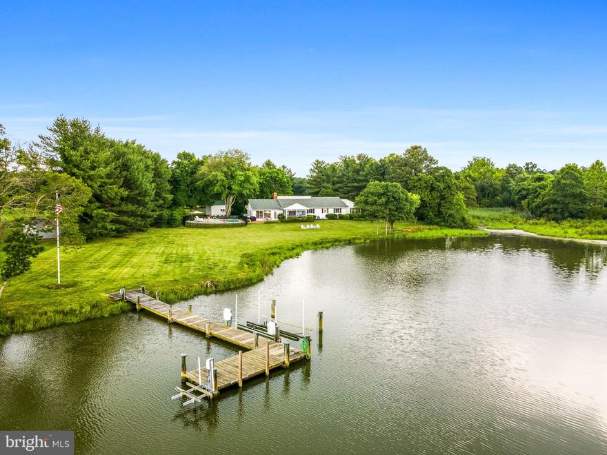Discover the epitome of waterfront living at Serenity Cove, perfectly situated on 2.27 acres with beautiful water views of Newcomb Creek. This property is conveniently located between the charming towns of Easton and St. Michael's, just a short 10-minute drive to either town for an array of dining and shopping options. Approximately 90 minutes from Washington D.C., Serenity Cove serves as an idyllic escape from city life.
Arrive via a long tree-lined driveway that enhances the property's sense of seclusion and privacy. This beautifully updated, expansive home boasts over 3,000 square feet of comfortable living space, all on one level, designed for both relaxation and entertainment.
Experience outdoor living at its finest with a newly renovated waterside pool, ideal for enjoying breathtaking sunsets and golden hour. The expansive lawn is perfect for lawn games and other activities, while the screened-in porch offers a serene spot to watch waterfowl gather in the cove. Savor a quintessential Maryland crab feast on the brick patio or fish and crab off the private dock equipped with a boat lift on Newcomb Creek. Take delightful boat trips up the Miles River to St. Michael's for unique dining adventures.
Inside, enjoy four spacious bedrooms and three full bathrooms, including a serene primary suite with cathedral ceilings, an en-suite bathroom, plantation shutters, a sitting area, and a large walk-in closet with built-in shelving, comfort is assured. The living room, with its hardwood flooring, fireplace, and beautiful built-ins, is perfect for cozy evenings. A separate office, elegantly appointed with glass French doors and extensive built-ins, provides an ideal setting for working from home. The gourmet kitchen features wooden cabinetry, granite countertops, new stainless steel appliances, and an open dining area with a built-in China cabinet. An oversized family room, with a wall of windows, offers breathtaking views of the water and yard. Additional features include a laundry room with cabinetry, an extra refrigerator, and ample storage.
Serenity Cove offers the perfect blend of elegance and comfort creating the ultimate waterfront living experience on the Eastern Shore!