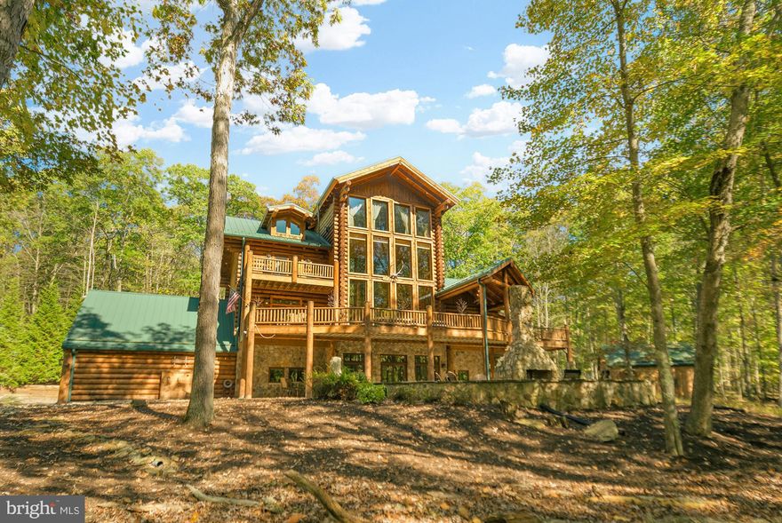 Welcome to 2725 Stockslager Road, one of Deep Creek Lake's most coveted properties. This custom-built log home is set against a picturesque landscape in Western Maryland, offering breathtaking nature views and embodying mountain charm and adventure. This home showcases impeccable craftsmanship, seamlessly blending with its natural surroundings while providing unrivaled comfort. Nestled on 1.03 acres, it ensures abundant privacy and is just a short, level walk to lake access with a deeded dock slip. 

With soaring cathedral ceilings that bathe the interior in natural light, the home features four finished levels, providing generous space for everyone. The property itself boasts a luxurious soaking hot tub, sauna, multiple bars, a family room, game room, den, dual washers and dryers, bar areas, an exquisite outdoor fireplace, a new Blackstone grill, radiant floor heating, and a custom wine barrel deck firepit along with an attached two-car garage and a detached 2-car garage with unfinished loft space.

Recently upgraded with several enhancements, this meticulously maintained home features fresh exterior staining,  a Savant home control system, a house generator, a new alarm system, and two new hot water heaters and boiler for radiant floor heating. New outdoor furniture and LED lighting enhance the exterior ambiance.

Inside, you'll find a warm and elegant atmosphere, featuring a native stone gas fireplace and custom touches that add rustic charm. Retreat to one of five en-suite bedrooms, each designed for maximum comfort with a private bath and a cozy fireplace. The loft area offers stunning views, perfect for entertaining or quiet relaxation.

Don’t miss this rare opportunity to own a remarkable property that seamlessly combines luxury, comfort, and natural beauty in the prestigious Sandy Beach community of Deep Creek Lake. This residence epitomizes resort living.  Schedule your private tour today to discover the pinnacle of Deep Creek Lake real estate. Adjoining lot (if still available) may also be purchased for $325,000, giving you an additional 1.03 acres of privacy.