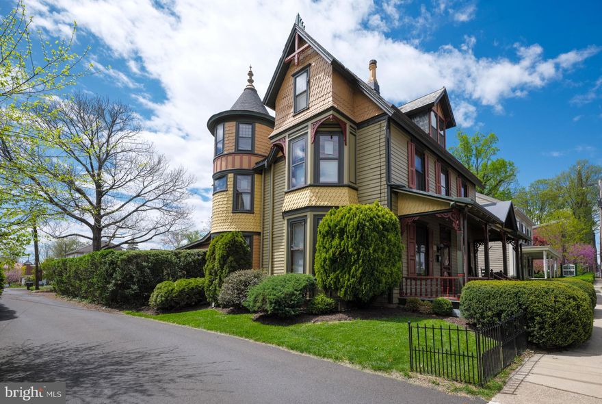 Step into a piece of Bucks County’s history with the Wm. Hager House, an 1851 Victorian that beautifully blends period architecture with the convenience of borough living. From its striking three-story turret and slate gable roof to the ornamental cresting and intricate wood details, this home reflects the artistry and craftsmanship of the 19th century, preserved with pride and care. As you enter, original stained-glass windows scatter colorful light across rich hardwood floors, setting the tone for the character that defines every room. The living room offers large windows and gracious proportions, while the family room with built-in bench and shelves provides a cozy retreat for reading or conversation. The formal dining room is ideal for entertaining, with room for memorable gatherings.
The kitchen enjoys garden views from all angles, newer appliances, spacious pantry, and convenient half bath—combining vintage charm with modern function. Upstairs, the second and third floors host three comfortable bedrooms, bathed in natural light, along with abundant storage. Behind the home, a screened-in porch offers a peaceful spot for morning coffee or evening relaxation. The fenced in grounds are a highlight: mature English-style landscaping, stone-edged beds, and a spectacular wisteria vine draping the fence bring seasonal beauty and timeless appeal. Whether hosting a summer gathering or simply enjoying quiet moments, the outdoor spaces offer a private retreat in the middle of town. A detached 2-car garage and driveway with off street parking add rare practicality—an uncommon advantage in the borough. Steps to shops, restaurants, cafés, and cultural attractions via tree-lined streets that embody the best of borough living. Whether you envision it as a gracious family home, an elegant professional office, or a blend of both, this property offers the rare chance to live—and work—within a piece of Doylestown’s story.
