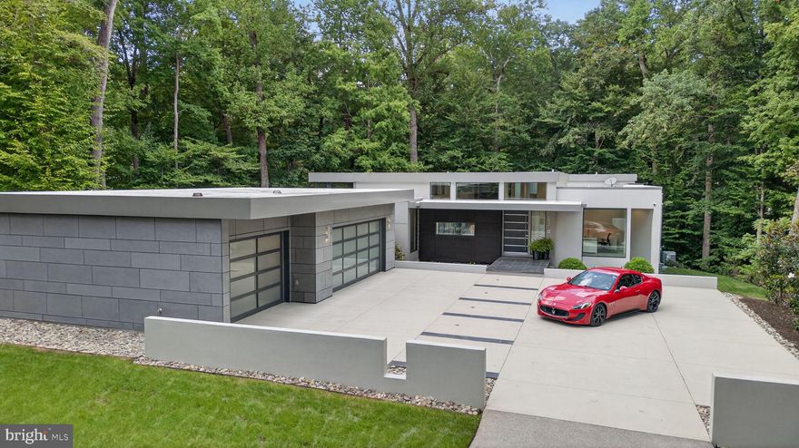 A rare fusion of innovation, design, and luxury– a cutting-edge architectural residence nestled within the gates of Kingsmill, Williamsburg’s premier Resort community. Framed by mature woodlands and tucked into a private terraced lot, the home flows effortlessly across its modern open floor plan, elevated throughout by 8’ Marvin Modern Collection windows. The gourmet kitchen is appointed with top-of-the-line Miele appliances , gorgeous stone countertops and sleek custom cabinetry. Retreat to a serene primary suite with custom closets and spa-inspired bath. Two additional bedrooms share another ensuite bath on the main level with a private office off the front entrance. A screened porch, terrace, and firepit make this home perfect for entertaining. The lower level features a stunning cantilevered staircase, wet bar and recreation room and a state of the art home theater that delivers a true cinematic experience. A fourth bedroom is easily used as a home gym or flex space with a conditioned mechanical room and an immaculate crawl space. Beyond the aesthetics lies an infrastructure few homes can match. Live in sophistication—surrounded by privacy, nature, and resort-style amenities.