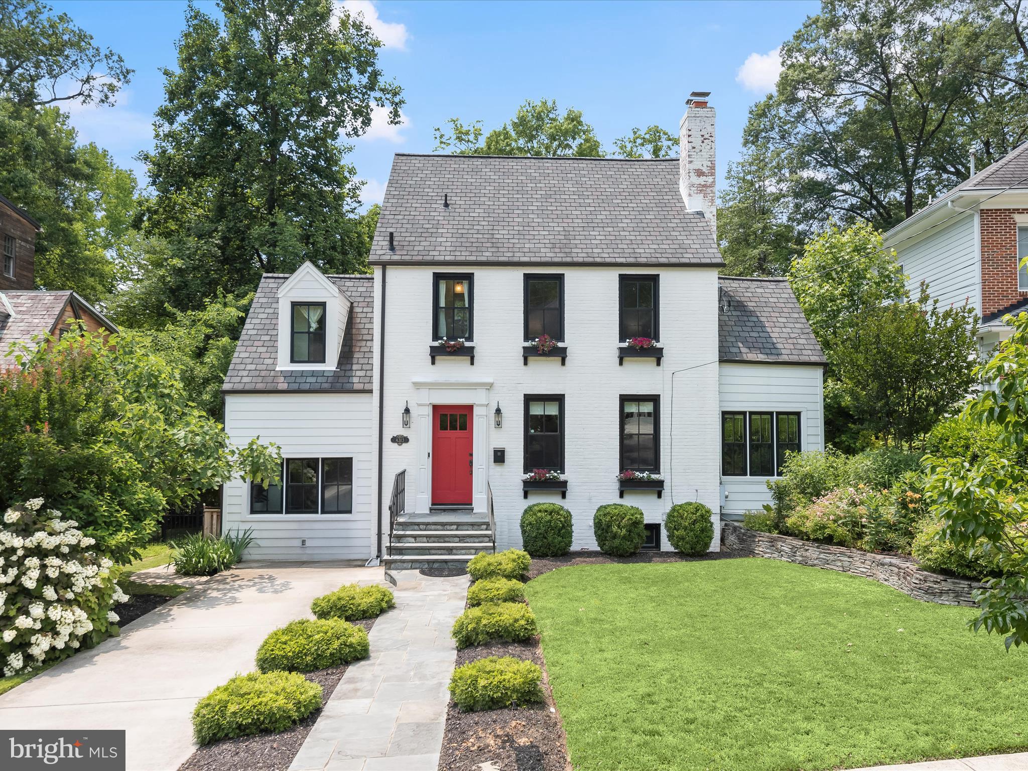 4313 Woodberry Street blends the timeless charm of a 1935 custom-built Colonial with the modern updates today’s lifestyle demands. Located in the heart of historic University Park, this beautifully renovated home sits just steps from the town park, playground, charging station, and more offering the perfect mix of community and convenience. Curb appeal abounds with a new blue stone walkway, window boxes, HardiPlank siding, recently replaced roof, gutters, downspouts, and painted exterior. Inside, original character meets thoughtful updates. The living room welcomes you with crown molding and a brick-accented fireplace, while refinished hardwood floors flow throughout. The fully redesigned kitchen features white cabinetry with display panels, a tiled backsplash, stone countertops, stainless steel appliances, gas range with hood, and an adjoining dining space complete with wainscoting.
Just beyond, a bright family room with bump-out windows opens to the backyard through a convenient side entrance. A sunroom off the living makes the perfect office or reading nook. The main level also includes a stylish full bath, along with a mudroom and laundry space outfitted with custom cabinetry and a built-in drop zone for the day’s essentials. Upstairs, the primary bedroom offers a walk-in closet and private en-suite bath. Two additional bedrooms complete this level, one currently designed as a boutique-style dressing room with custom built-ins-easily converted back to a bedroom if desired. A third full bath serves this floor, and a finished attic provides a spacious fourth bedroom on the top level.
The lower level has been completely transformed to include a second kitchen and dining area, a sleek full bath with a walk-in shower, and a flex room ideal as a recreation space or fifth bedroom. With its level walk-out, this area is perfect for an in-law suite, or a desirable rental setup. The backyard is equally impressive, featuring a patio, lush tiered gardens, raspberry and blueberry bushes, and an irrigation system to keep it all thriving. Additional updates include recently replaced windows, doors, laminate flooring, and interior paint throughout. Commuters and explorers alike will love being so close to two Metro stations, the MARC train, University of Maryland, Trader Joe’s, Riverdale Park Station including Whole Foods, Burton’s, Gold’s Gym, and more. The upcoming Purple Line will only enhance this ideal location. A rare blend of history, style, and modern comfort in sought-after University Park.