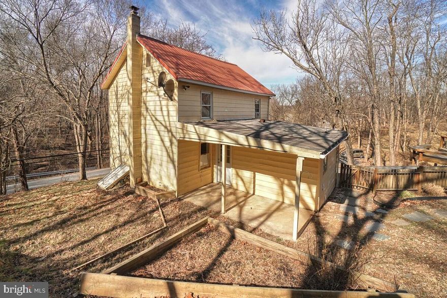 **Charming Rustic Retreat with Acreage and Stream**

Welcome to this unique and inviting adorable home, nestled on a 3.8-acre property. The main level boasts an open floor plan, perfect for cozy living and entertaining. Enjoy the warmth and character of hardwood floors and beamed ceilings, complemented by a charming wood stove that promises cozy evenings.

The bedrooms are a rustic haven, featuring wood flooring and exposed log walls, adding to the home's natural charm. The property includes multiple outbuildings, each offering its own unique benefits. Take advantage of the large workshop with electricity, perfect for projects and hobbies. The workshop's deck provides a serene view overlooking the property, ideal for morning coffee or evening relaxation. Enjoy the luxury of an outdoor shower. There is a structure on the property that appears to be a historic one room schoolhouse.  Additionally, there are multiple chicken coops, making it easy to embrace and sustain a self-sufficient lifestyle

Set on a half-acre lot, this home comes with an additional 3.3-acre lot tax# 1107199279, creating a total of 3.8 acres of natural beauty. A stream runs through the property, adding to the tranquil atmosphere and offering endless possibilities for outdoor enjoyment.

All of this and located just a few miles from Urbana!!

While this property needs some work, it holds incredible potential for the right buyer. Embrace the opportunity to create your dream rustic retreat in this idyllic setting. Don’t miss out on this rare gem!