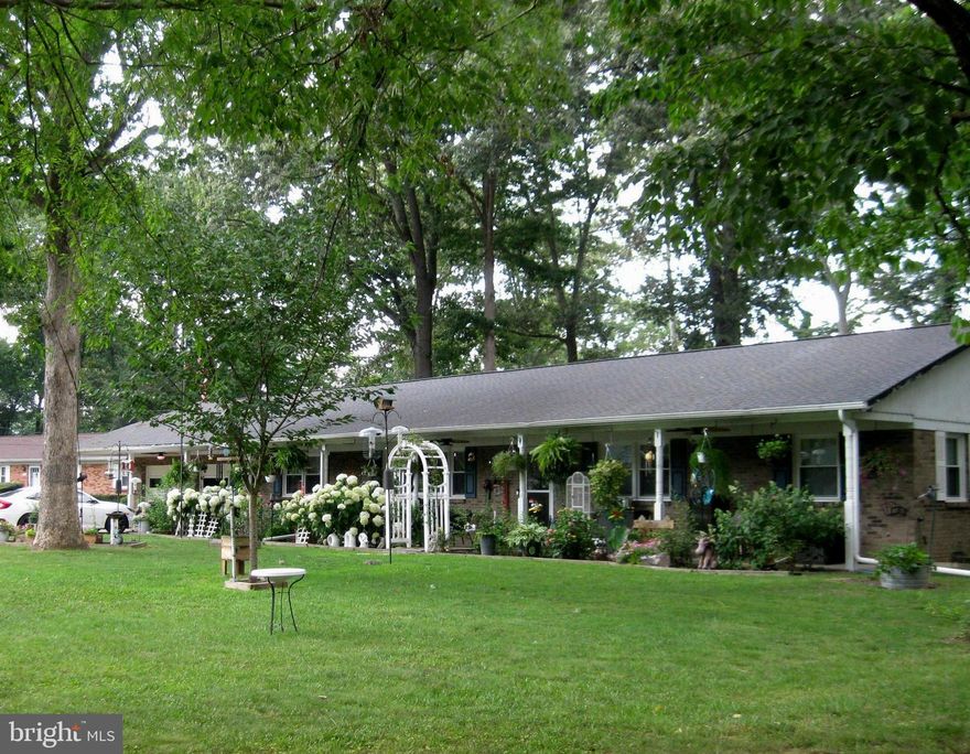 Back on the market! Owner made even more improvements to this beautiful open concept rambler.  Its one level living at its best!  Sits on half an acre with a fenced in back yard. Front yard has an electric fence. Large decking platform in the backyard to enjoy cookouts and nature.  Huge front porch that extends the length of the house.  Front porch has 4 beautiful fans to cool you down in the summer heat. Three sheds in the backyard. New windows, new flooring in living room, kitchen, and eating area.  Bedrooms have hardwood floors.  Bathroom in primary bedroom completed remodeled and 2nd bathroom has a fresh look!  Freshly painted living area.  Fans in all rooms and recessed lighting in one bedroom and by fireplace.  New dishwasher in the kitchen. Thermostat controlled pellet stove. Two car garage is divided with a wall but there is access through a door. Far side of garage has heating and cooling. White cabinets in garage convey with house.  One side of garage has a automatic door opener but not currently being  used and has shelves in front of the door (these selves also convey).  Tree recently taken down in the backyard and owner is having removed.  Fence will also be repaired.  It is conveniently located to Rt. 301 to make any commute a breeze. Make this home yours before it is gone!  There are audio/video cameras outside and inside common area. Some plants in the front yard do not convey.    Home Warranty included!