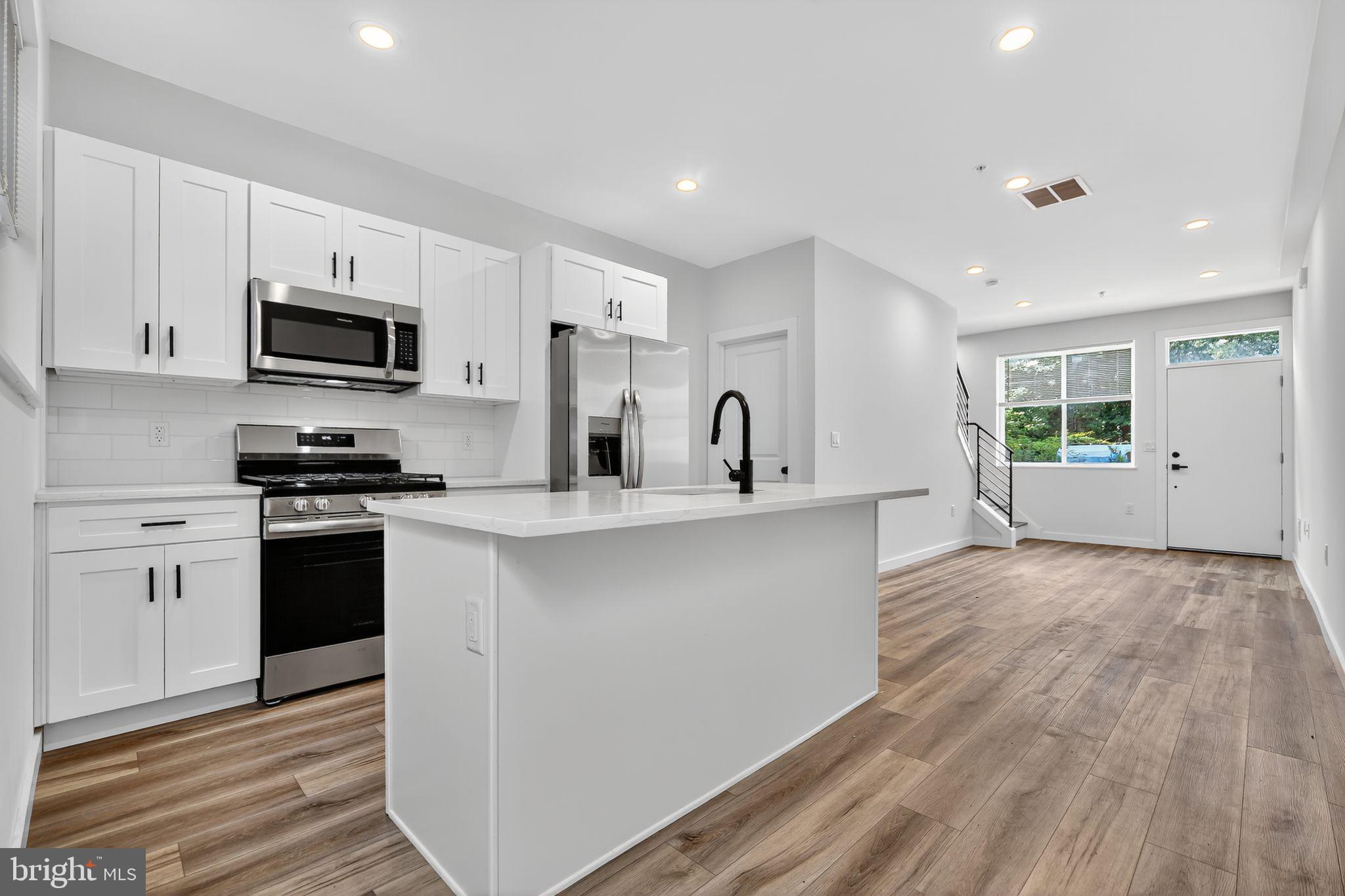 New Construction in Grays Ferry! This striking townhome at 3209 Latona Street features a sleek modern facade with bold lines, oversized windows, and a raised entry that sets the tone for the contemporary design found inside. The main level is bright and open, with wide-plank flooring that flows through a spacious living and dining area into a stylish kitchen complete with white shaker cabinetry, quartz counters, stainless-steel appliances and a large island that doubles as a breakfast bar. At the rear, a full-light glass door opens to a private fenced patio, perfect for grilling or relaxing outdoors. Throughout the home, high ceilings, recessed lighting, and large windows create a bright, airy feel.
The second floor offers two generous bedrooms with recessed lighting and ample closet space, along with a well-appointed full bath. The third floor is dedicated to a private primary suite, complete with a large bedroom, walk-in closet, and en-suite bath. From here, a pilot house leads to the expansive roof deck, where panoramic skyline views extend the living space outdoors and create the perfect setting for entertaining or relaxing.
The lower level spans 313 square feet and remains unfinished, but includes laundry hookups and can be customized by the builder into a family room, office, or guest suite for additional living space. A 10-year tax abatement has been granted, adding long-term financial benefit. The Grays Ferry location provides easy access to University City, Center City, major hospitals, and the South Street bridge. Parks and trails along the Schuylkill River, neighborhood cafés, and shopping along Washington Avenue are just minutes away, and commuters will appreciate proximity to I-76 and public transportation. With its modern design, indoor–outdoor living, flexible basement option, and valuable tax abatement, 3209 Latona Street is a move-in-ready home that blends style, comfort, and convenience in Grays Ferry.