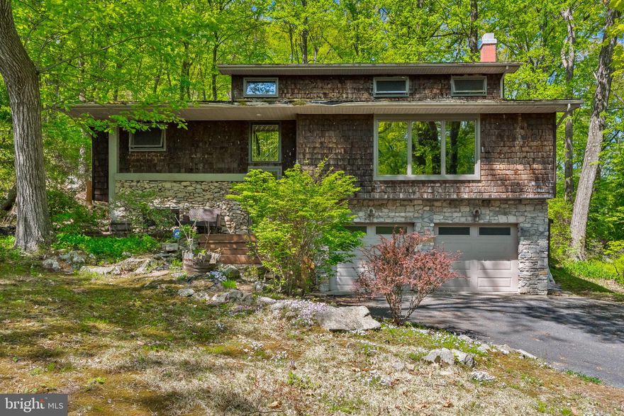 Do you want to feel like you live in your very own mountain house? Well you have found the perfect home! Nestled in a beautiful wooded setting on a cul-de-sac street, you are completely surrounded by nature, with Huge full length windows allowing for unobstructed peaceful views.  Each room on the first level is extremely spacious, offering multiple living options. Double sets of french doors allow for privacy if that is needed. There is a floor to ceiling lava rock propane fireplace in the front room,  a propane stove in the addition and a pellet stove in the basement. The basement also offers an additional flex area for an office, man cave or family room, a powder room and garage access. The second floor has 4 very large bedrooms, one with an en-suite. Dual zone central air is another bonus! This home is a hidden jem waiting for its new owners!