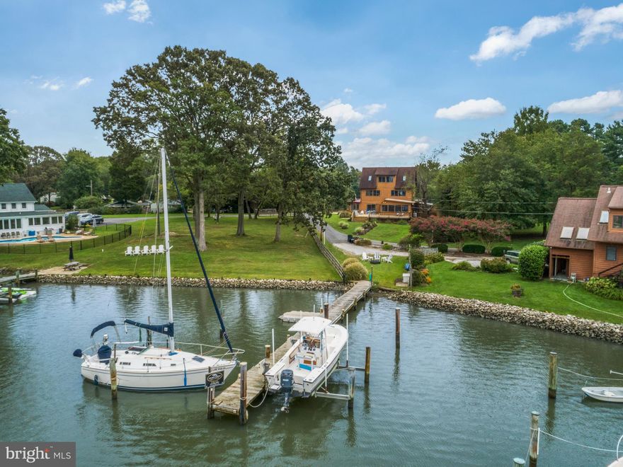 EDGEWATER WATERFRONT on .72 acres!!  Breathtaking sunset views await you at this prime waterfront property located on a private lane of million-dollar waterfront homes.  Water views fill this sunny home on three levels.  The living room and kitchen-sun room walk out to a huge deck overlooking the water.  The kitchen has gorgeous quartz countertops including an 8-foot island with seating.  The kitchen flows into the adjoining sunroom for relaxed dining or sitting. The living room is light and bright with white painted beams for a modern, coastal vibe.  Decorator-selected neutral creams and greys have been used in the beautiful updated flooring and freshly painted walls.  There is a spacious main level guest bedroom and full bathroom.  Also on the main level is a library-study area and a large game-rec-TV room with access to the backyard and garage, as well as the laundry room with added storage. Lots and lots of windows bring in natural light to the 2nd floor which is home to the master bedroom suite with bath, and a large open area currently used for a home business office, plus an additional bedroom. Huge master bedroom with his and her (walk-in) closets and a balcony that overlooks the water and has stairs leading down to the private backyard.  Third floor has 2 bedrooms, full bath, and a common area between, with spectacular water views that could accommodate another sleeping area or would be a great hang-out room. This property also boasts multiple outdoor living spaces.  In addition to  the massive deck space, enjoy relaxing in privacy in the hot tub in the screened porch or sunbathe on the patio in the fenced back yard; or make use of the huge fenced side yard for more active recreation or birdwatching the overlooking cove. This is a fantastic location for boating whether you like to sail or fish or just paddle board.  You can dock your sailboat (4.5 ft water depth) and power boat (10,000lb boat lift) and other water toys at the pier located on the protected waters of Cadle Creek with easy access to the scenic Rhode and West Rivers and the Bay.  Enjoy a raft-up in the popular waters off the Smithsonian's preserve or cruise the West River for dinner at a waterfront restaurant.  It's a quick sail to the Chesapeake Bay for fishing and further explorations to Annapolis and the Eastern Shore!  Or bring the outdoors to you and enjoy relaxing and entertaining on the spacious deck.  Ideal place for a crab feast! Close to restaurants, hiking trails, beaches and schools.  Blue ribbon school district! This property offers extensive out buildings to house cars, toys, tools, etc, etc!!  The main garage is an oversized 2-car garage with extra room for storage and moving around.  Next to that is a separate workshop. Next to that is the former 1-car garage which was moved to make room for the new garage addition.  There is another large open shed and a gardening shed!  There is also outdoor storage for kayaks and paddle boards under the deck and under the sunroom.   This property offers so much for the buyer looking for space and proximity to the delights of our area. Would make a wonderful primary home, second home or VRBO.  The current owners have enjoyed this home for years but now they are ready to pass the torch.  Don't wait!  Come take a look and make this your next home!!   Finished square footage on tax records is incorrect.   Should be approximately 2800 SF.   See the virtual tour video at https://www.youtube.com/watch?v=_Ytm_JpOSYE&t=13s