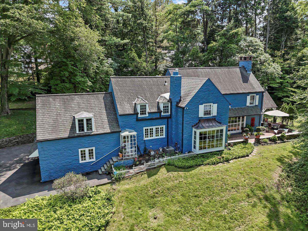 This beautiful French Country-style stone home is set on nearly an acre of lush, park-like grounds in desirable Northside Bryn Mawr. Tucked along a quiet section of Old Gulph Road, yet just minutes from downtown Bryn Mawr's shops, dining, and train station, this spacious 5-bedroom, 5.5-bathroom residence offers timeless charm, generous living areas, and exceptional convenience. A welcoming foyer opens to the sunlit living room featuring a wood-burning fireplace, large bay window, built-in shelving, random-width hardwood flooring, and French doors that lead to a serene flagstone patio. The formal dining room, also with a bay window and patio access, offers an elegant setting for entertaining. The den provides a quiet retreat with custom bookshelves and a wet bar. The spacious eat-in kitchen features granite countertops, stainless steel appliances, a built-in refrigerator, and plenty of cabinetry—ideal for everyday living and entertaining alike. A guest powder room completes the main level. Upstairs, the generously sized primary suite includes two full bathrooms, one with heated floors and ample closet space. Four additional bedrooms are all well-sized, each with direct access to a bathroom. One of these bedrooms is accessed via a private rear staircase and includes a cozy sitting area and full bath—perfect for guests, in-laws, or an au pair. The finished lower level features a large family room, a fifth full bathroom, laundry area, and extensive unfinished space ideal for storage, a gym, or workshop. Outside, enjoy the beautifully landscaped yard, a spacious open patio, and a covered area for shaded outdoor relaxation or dining. A two-car attached garage completes this exceptional property. Don’t miss this opportunity to own a gracious home in one of Bryn Mawr’s most coveted neighborhoods—offering space, character, and a prime location.