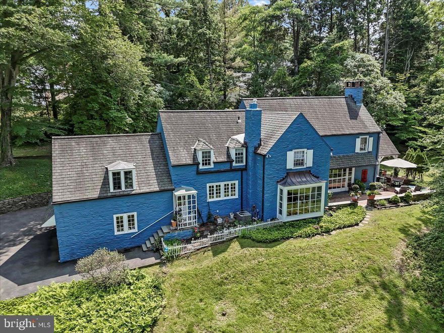 This beautiful French Country-style stone home is set on nearly an acre of lush, park-like grounds in desirable Northside Bryn Mawr. Tucked along a quiet section of Old Gulph Road, yet just minutes from downtown Bryn Mawr's shops, dining, and train station, this spacious 5-bedroom, 5.5-bathroom residence offers timeless charm, generous living areas, and exceptional convenience. A welcoming foyer opens to the sunlit living room featuring a wood-burning fireplace, large bay window, built-in shelving, random-width hardwood flooring, and French doors that lead to a serene flagstone patio. The formal dining room, also with a bay window and patio access, offers an elegant setting for entertaining. The den provides a quiet retreat with custom bookshelves and a wet bar. The spacious eat-in kitchen features granite countertops, stainless steel appliances, a built-in refrigerator, and plenty of cabinetry—ideal for everyday living and entertaining alike. A guest powder room completes the main level. Upstairs, the generously sized primary suite includes two full bathrooms, one with heated floors and ample closet space. Four additional bedrooms are all well-sized, each with direct access to a bathroom. One of these bedrooms is accessed via a private rear staircase and includes a cozy sitting area and full bath—perfect for guests, in-laws, or an au pair. The finished lower level features a large family room, a fifth full bathroom, laundry area, and extensive unfinished space ideal for storage, a gym, or workshop. Outside, enjoy the beautifully landscaped yard, a spacious open patio, and a covered area for shaded outdoor relaxation or dining. A two-car attached garage completes this exceptional property. Don’t miss this opportunity to own a gracious home in one of Bryn Mawr’s most coveted neighborhoods—offering space, character, and a prime location.