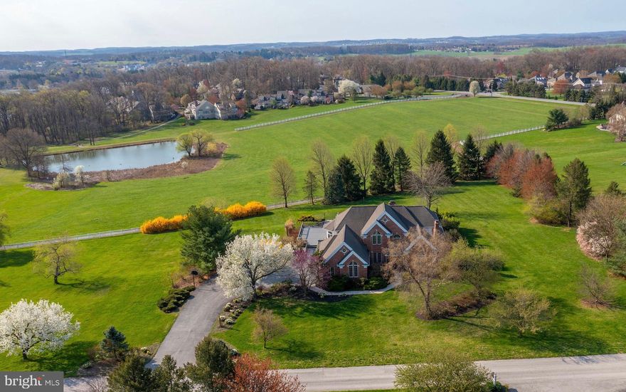 Privately situated down a quiet lane, this stunning home features beautiful architecture, quality finishes, and impressive amenities. Offering 5 bedrooms, 4 full baths, and 1 half bath, incorporated into 6,385 square feet of living space.  The moment you walk through the front door, you will be impressed with the two story grand foyer. The first floor features a formal living room, dining room, and a great room that features a stone fireplace and hardwood floors. Presently, the Great Room is enjoyed for hosting large dinners and has space around the fireplace to relax and read.  There is a first floor Office/Den off the center hall with custom built-in bookcases, desk, a beautiful gas fireplace with marble surround and hardwood floors. There is a private entrance from the Office to the first floor Primary Ensuite. The Primary Bedroom features a tray ceiling, an oversized walk-in closet, and a large Primary Bath with everything you would want from a walk-in tile shower, jacuzzi tub and so much more.  A favorite area of the home that all will enjoy is the Chefs’ Kitchen with an oversized center island, top grade appliances and granite counters. Part of this beautiful Kitchen is the Eat- In bay area with walls of windows to sit and enjoy the views. The Kitchen and Eat-In area open into the Family Room with two-story windows that look out over the Rosenmiller Farm and Pond. Additionally, from this area you can step out onto the large deck. The first floor also features a powder room and large laundry room. There are two staircases to the second floor. The front center hall staircase showcases the stunning craftsmanship of the home and the rear staircase is perfectly located just off of the Kitchen.  There are three Bedrooms on the second floor. Bedroom Two offers a walk-in closet and Full Bath. Bedrooms Three and Four share a Full Bath area but each have their own sink and vanity.  The lower level of the home offers a large Rec Room with an area to enjoy all kinds of activities from ping pong, pool tables, or family nights of movies. There is a wonderful Kitchen in this area with a wrap around Bar sitting area. The fifth bedroom is located on this level and has a large window overlooking the pool with access to a full bath, and private entrance to the exterior. From this level, you have full access to the beautiful patios and in-ground pool.  The outdoor living space features gorgeous landscaping, flowering trees, perennials, and great spaces to play.  The home is part of the Rosenmiller Farm Home Association (RFHO). This allows you access to the private Bridle trail which meanders over two miles around the farm and through the woods. There are two newly renovated tennis/pickle courts and a children’s play area. You also can spend time fishing at the pond which is freshly stocked every year. All these amenities are within a few minutes walk from the home.  This is a rare opportunity to own a home that offers privacy in a great location with close proximity to the I 83, schools, shopping and major healthcare facilities located in York Suburban Schools.  This home is a comfortable balance of quality living.