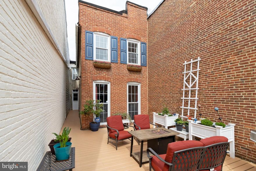 Battery ave Row home features a spacious front yard with deck and privacy fence.  Lots of  windows let in ample light. Exposed beams and exposed brick on the main floor.  *9ft ceilings*  A true wood burning fireplace.  Enviable kitchen complements original tin ceilings. Two bedroom walk thru that can be used for home office in front of your house.  Just renovated the full bathroom with dual sinks & W/D conveniently on bedroom level. Compact car parking pad. In the heart of Federal Hill, close to Inner Harbor, UA, hospitals & more.