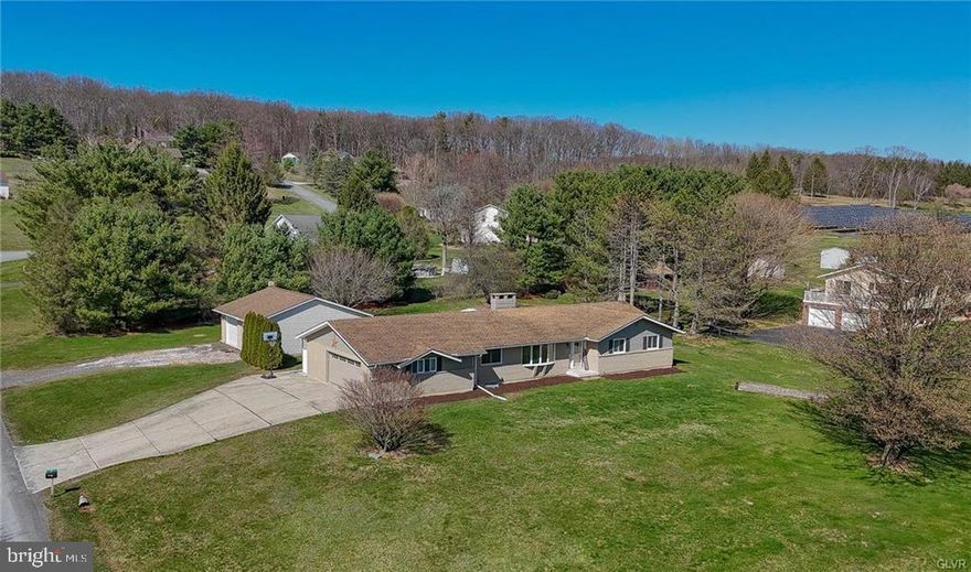 Multiple Offers Received. Highest and Best by Wednesday April 16 @ 1 PM.  This marvelous West Penn Ranch sits on a lovely corner lot and offers so much in addition to its lovely location! The main level begins with a foyer flowing effortlessly into the home’s sprawling living room which circles into the home’s open concept kitchen and dining room. The kitchen features lovely granite counters for ample workspace and shares a wood burning fireplace with the dining room! Tremendous flexibility in these living areas! Two well-sized bedrooms are served by the hall bath; a master bedroom offers double closets and ensuite! A half bath is conveniently set near the main-level laundry/mud room! An attached garage completes the main level. Downstairs, the lower level has been separated into several rooms, a family room with beautiful bar at its center. There are three rooms for utilities and storage, as well as a convenient walk-in closet, and another room serving as a home office! Outside, a covered concrete patio steps on to a gravel area currently home to a fire pit! An enormous bonus to this home is the 850sf detached garage. With power, water, and its own oil heat supply, this garage is a cut above, all the way up to its 9’9” ceiling! Insulated and with a trough drain in the concrete floor, this space has been thoughtfully created! Situated near the local elementary school, this home also puts you in excellent proximity to 309 for easy access to Tamaqua or the Greater Lehigh Valley!