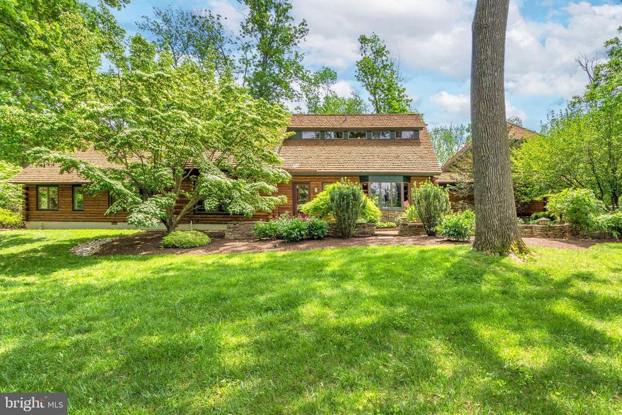 Welcome to this sophisticated, architectural log home offering the perfect blend of rustic charm and modern luxury. Located on one of Solebury’s premier roads, this home was meticulously crafted with superior workmanship and premier materials. The award winning design was built by local craftsman Kurt Hossley and has been featured in several log home magazines. The home offers an open floor plan with many beautiful and unique features. There are wide plank oak floors, cathedral ceilings, mercer tiles, walls of windows and handcrafted cabinets and doors throughout the home. The stunning living area features a huge floor to ceiling stone fireplace plus a dining area. There is a lovely bright kitchen with center island, a lounge, a sunroom and several guest rooms with 2 full baths completing the first floor. The second floor has a huge primary bedroom with windows overlooking the gardens, a beautiful full bath and an oversized walk-in closet. The home also features a separate staircase leading to a large bright bonus room with walls of cabinets and closets as well as having its own private deck. Throughout the home there are multiple doors that open to the gorgeous park like fenced outdoor living area. The flagstone patio extends the length of the home providing a magnificent area for al fresco dining and entertaining. There is an additional raised deck, a Koi pond with a waterfall, a brick fireplace and beautiful lush landscaped gardens as well as mature trees for privacy. This charming property situated on 1.5 acres just feels so much larger as it is nestled between much larger expansive estates. The upscale log home is a rare opportunity to own a luxurious private retreat that combines the rustic allure of hand crafted logs with modern sophistication. Conveniently located close to charming local towns offering shopping, dining and outdoor recreation, it is 70 minutes to NYC, 50 minutes to Philadelphia and 35 minutes to Princeton.
