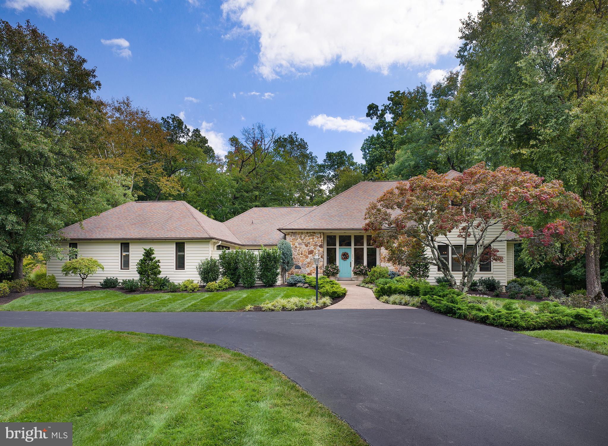 In the highly desirable estate section of Devon stands this classic stone farmhouse-inspired residence designed by Ann Capron. Embodying a sophisticated yet casual ambiance, it's a warm and inviting retreat. Nestled quietly in a cul-de-sac and surrounded by lush woodlands, the home's high ceilings, expansive windows, and ample skylights allow for a gentle interplay of natural light. The foyer, with its arches, introduces you to the varied spaces of the home. The spacious living room/great room is perfect for relaxed gatherings, accentuated by a 14-foot ceiling and three skylights. Adjacent is the dining area, seamlessly flowing into a bar nook. The kitchen, characterized by its functionality, boasts stainless steel appliances, including a Liebherr refrigerator and GE Monogram double ovens. Its granite countertops and four skylights enhance its charm. A family room, with its gas fireplace and floor-to-ceiling stone surround, adjoins the breakfast area and offers breathtaking views of the grounds. The main floor also houses the primary bedroom suite, emphasizing comfort with a skylight over the jacuzzi tub. Additional rooms can serve as dual offices or optional bedrooms. A mud/laundry room, directly accessible from the garage, ensures practicality with ample storage and a custom-built pantry. The second floor reveals two generously-sized bedrooms, each with walk-in closets and private sink areas, linked by a Jack-and-Jill bathroom that enjoys natural light from a skylight. The day lit, walk out lower level has a large recreational room with a fireplace, a fitness area with a sauna, a cedar closet, a workshop, and a powder room. The combination of leisure and utility is evident, with considerable storage space complementing the setting. Outdoors, a serene haven awaits with an Armond pool, spa, twin waterfalls, and detailed landscaping, complemented by a deck equipped with a Sunbrella awning. While already a gem in its own right, the home offers potential enhancements, with architect's plans detailing shower expansion, garage modifications for three cars, and additional living spaces. Its proximity to shops, dining, and transportation, makes this residence an unparalleled gem in design and location. Seller successfully appealed the real estate taxes, and they will be reduced by $6969 in 2024.