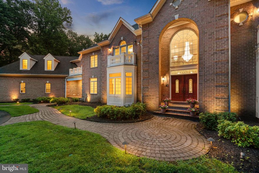 Welcome to this extraordinary all-brick Colonial estate, nestled on three serene, wooded acres in the prestigious Hawksfield Estates. Built by Greenfield Homes, this residence blends timeless architecture, expansive scale, and refined upgrades throughout. A long circular driveway, manicured landscaping, and extensive hardscaping set an impressive tone from the moment you arrive.Step inside the grand two-story foyer, where gleaming granite floors meet a breathtaking, custom-built staircase featuring ornate iron railings—a true architectural showpiece that anchors the home with grace and drama. An elevator shaft is also in place, ready for future installation if desired.Throughout the home, you’ll find rich hardwood floors, arched doorways, stately columns, and an abundance of natural light, all contributing to an elegant yet comfortable atmosphere.The formal living room features a semi-tray ceiling and bay window, while the formal dining room is perfect for entertaining with wainscoting, a statement chandelier, and a convenient butler’s pantry. The expansive gourmet kitchen is a chef’s dream—complete with a Sub-Zero® refrigerator, double ovens, a six-burner range with griddle, oversized hood, warming drawer, Bosch® dishwasher, butler’s kitchen, and a large center island with bar seating. The sun-drenched morning room with bay windows shares a dual-sided gas fireplace with the soaring two-story family room, anchored by arched windows and incredible ceiling height.The main level offers remarkable flexibility with multiple bedroom suites, including an in-law suite with en-suite bath and walk-in closet, a separate guest suite with a full bath, a bidet , a walk-in closet and balcony, and a third flex bedroom or study. Two powder rooms, a dedicated home office, and a laundry room complete the level.
Upstairs, the luxurious owner’s suite is its own private retreat. It features a spacious bedroom with tray ceiling, dual-sided fireplace, and a private sitting room, perfect for a nursery or meditation space. You'll also find a separate study/home office within the suite, ideal for working from home in peace. Two walk-in closets, including a cedar closet, flank a spa-inspired bath with a soaking tub, dual vanities, a bidet-equipped water closet, and direct access to a custom dressing room with built-ins and a seated vanity. Three additional bedrooms on this level offer walk-in closets, private  baths, balconies, and flexible-use sitting rooms.  A second laundry closet is always conveniently located on this level.The walk-out lower level is an entertainer’s dream, featuring a home theater, full second kitchen,a recreation room, gaming area, dance floor, home gym, full bath, powder room, and a 8th bedroom with luxury vinyl floors and walk-in closet.  Additionally, it includes a third laundry room and additional storage.  Bonus: Unique lower-level exit that leads directly to the main level garage, perfect for seamless event access.Outdoor living is equally spectacular, with a covered patio, upper-level deck with built-in bench seating, and a charming gazebo overlooking your peaceful, wooded backyard oasis.This stunning estate offers refined living, custom craftsmanship, and room to live, entertain, and grow—all in one of the area’s most coveted communities.  Updates include: Freshly Painted [2025], Roof [2021], Utility Room - Water Heater #1 [2024] & HVAC #1 [2021], Utility Closet - Water Heater #2 [2011] & HVAC #2 [2013].