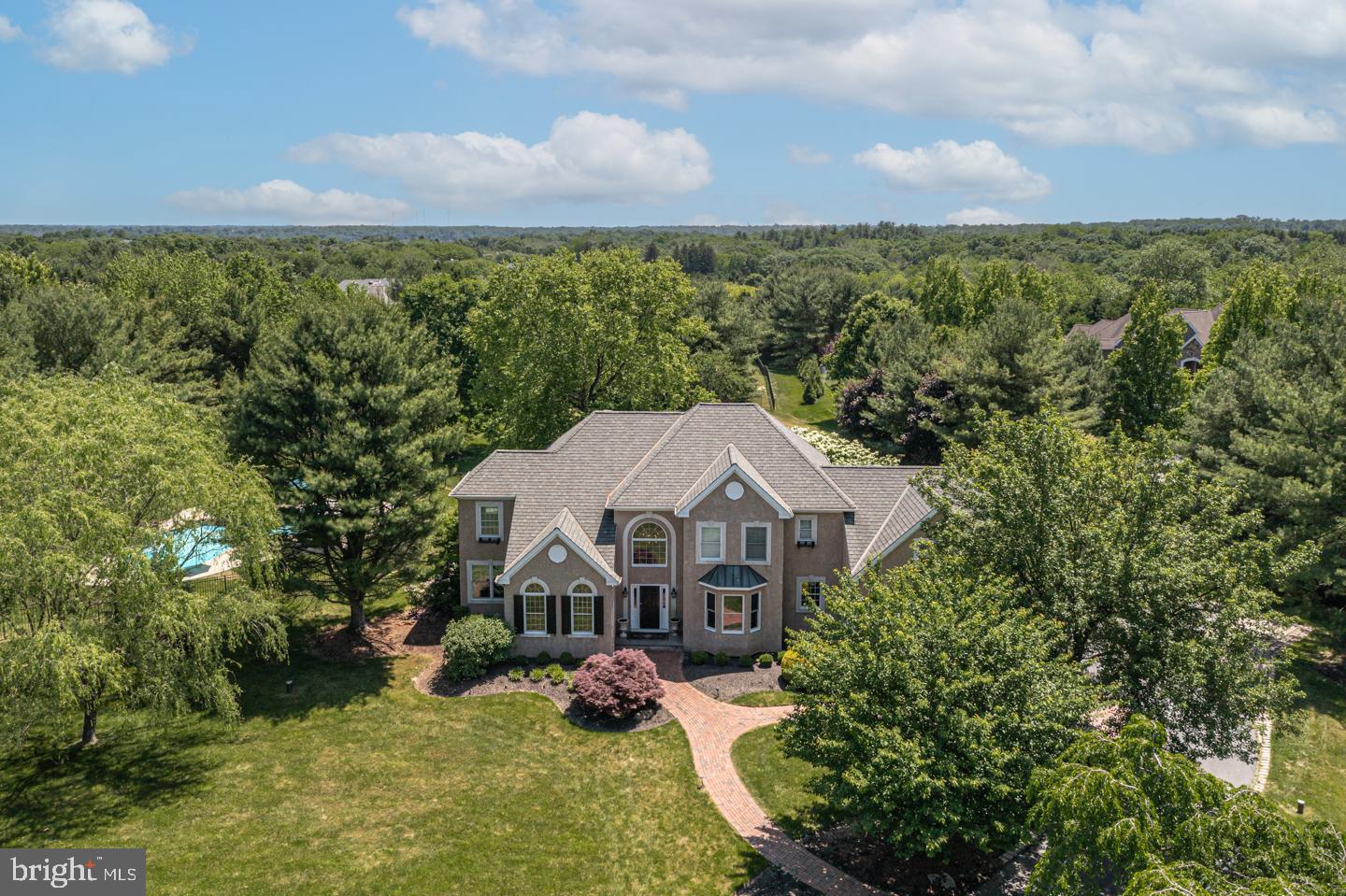 An exceptional value awaits your arrival on 2+ prime acres in Upper Makefield's premier community of Longmeadow. Set on a private cul-de-sac surrounded by mature, beautifully landscaped grounds, this 4 bedroom, 4 full 1 half bath home offers striking custom detail and exquisite finishes around every corner. Stroll down the stunning brick walkway and enter into a grand 2-story foyer showcasing an ornamental wrought iron and wood staircase and hardwood floors spanning throughout the majority of the main level. The formal Living Room with wood burning fireplace anchor the entryway along with the spacious Dining Room adorned with custom millwork. The neighboring Great Room opens to the eat-in Kitchen and boasts a floor-to-ceiling fireplace set in the center of a wall of windows allowing for wonderful natural light. A chef’s delight, the gourmet Kitchen is outfitted with an abundance of custom cabinetry, stainless steel appliances, granite countertops, center island, and connects to a convenient butler’s pantry with back staircase making it ideal for hosting gatherings. A half bath and private Study/Sunroom can also be found on this level providing the perfect setup for virtual working. Unwind upstairs after a long day in the Main Suite with its cozy sitting area and sumptuous Bath. A Princess Suite and 2 additional generously-sized Bedrooms that share a Hallway Bath complete this upper level. The finished lower level is wonderful bonus space offering additional living areas, large fitness room, full bath and an abundance of storage! Enjoy the magnificent outdoor amenities with friends and family at the heated pool with spa and rock waterfall and dine al fresco under the pergola. Additional highlights include a built-in grill, 3-car garage, Geothermal heating/cooling. Just minutes away from historic Washington Crossing Park, the Delaware River and the I-295 corridor for easy commuting to both Philadelphia and NYC. This is a one-of-a-kind custom home conveniently located to everything and in the award-winning Council Rock School District.