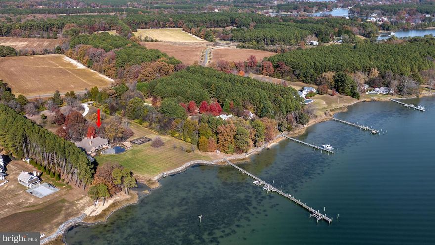 Located within 2 miles of historic St. Michaels this exceptional waterfront estate blends timeless elegance with a resort-style setting. This 4,200± sq. ft. custom, single-level all brick residence showcases soaring ceilings, an abundance of natural light, and panoramic views of Broad Creek from almost every room.  A huge great room featuring a large brick fireplace and open living / dining options. There is a gorgeous gourmet kitchen complete with quartz counters, stainless steel appliances and walk in pantry, seamlessly flowing into a spacious family room with a timeless double sided brick fireplace and built-in bookcase.  An architecturally stunning screened octagonal porch—perfect for relaxing or entertaining. A brick-floored sunroom with gas fireplace and pool bath leads to an expansive patio overlooking the waterside pool, framed by a rock waterfall, and custom gazebo. The luxurious primary suite features cathedral ceilings, French doors leading to the sunroom and a spa-inspired bath with walk in tile shower and soaking tub. Two additional en-suite bedrooms, a large den with custom built-ins perfect for library or additional bedroom, and a spacious butler’s pantry with granite counters, extra refrigerator, stainless sink and additional cabinetry. A separate study and conditioned workshop offer versatile space. Set on five beautifully landscaped acres with southern exposure, the property boasts 370+/- feet of protected shoreline and a 350-foot private pier with 6 feet of deep water. Boating enthusiasts will appreciate the 15,000-lb and 8,000-lb lifts, two additional slips, and a floating dock.  A gated 30' x 40' flower/vegetable garden with raised beds, an oversized 2-car garage and large garden shed complete this beautiful home. Septic is for 3 BR but office could be BR #4.