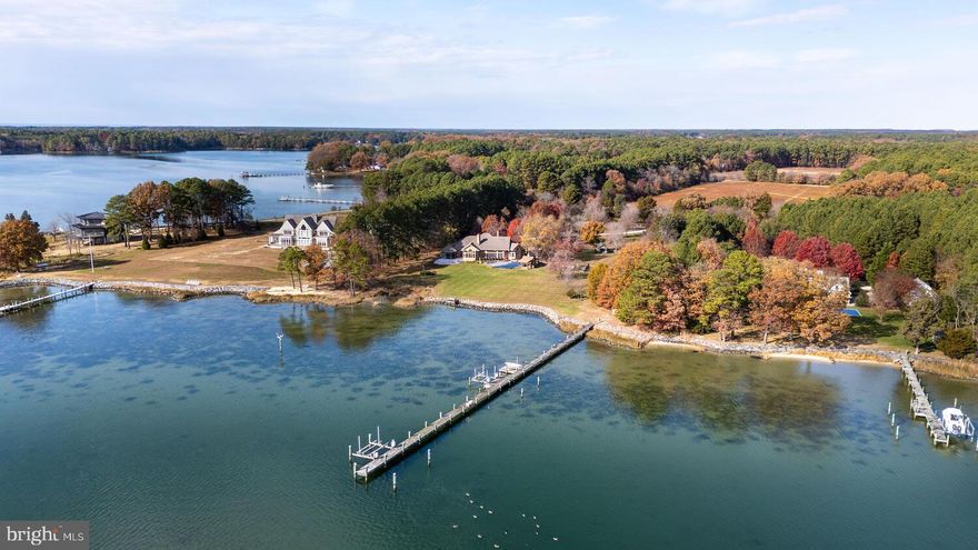 Located within 2 miles of historic St. Michaels this exceptional waterfront estate blends timeless elegance with a resort-style setting. This 4,200± sq. ft. custom, single-level all brick residence showcases soaring ceilings, an abundance of natural light, and panoramic views of Broad Creek from almost every room.  A huge great room featuring a large brick fireplace and open living / dining options. There is a gorgeous gourmet kitchen complete with quartz counters, stainless steel appliances and walk in pantry, seamlessly flowing into a spacious family room with a timeless double sided brick fireplace and built-in bookcase.  An architecturally stunning screened octagonal porch—perfect for relaxing or entertaining. A brick-floored sunroom with gas fireplace and pool bath leads to an expansive patio overlooking the waterside pool, framed by a rock waterfall, and custom gazebo. The luxurious primary suite features cathedral ceilings, French doors leading to the sunroom and a spa-inspired bath with walk in tile shower and soaking tub. Two additional en-suite bedrooms, a large den with custom built-ins perfect for library or additional bedroom, and a spacious butler’s pantry with granite counters, extra refrigerator, stainless sink and additional cabinetry. A separate study and conditioned workshop offer versatile space. Set on five beautifully landscaped acres with southern exposure, the property boasts 370+/- feet of protected shoreline and a 350-foot private pier with 6 feet of deep water. Boating enthusiasts will appreciate the 15,000-lb and 8,000-lb lifts, two additional slips, and a floating dock.  A gated 30' x 40' flower/vegetable garden with raised beds, an oversized 2-car garage and large garden shed complete this beautiful home. Septic is for 3 BR but office could be BR #4.