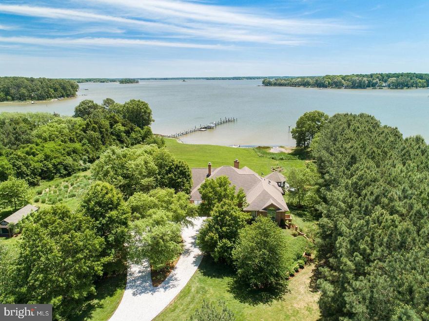 Located within 2 miles of historic St. Michaels this exceptional waterfront estate blends timeless elegance with a resort-style setting. This 4,200± sq. ft. custom, single-level all brick residence showcases soaring ceilings, an abundance of natural light, and panoramic views of Broad Creek from almost every room.  A huge great room featuring a large brick fireplace and open living / dining options. There is a gorgeous gourmet kitchen complete with quartz counters, stainless steel appliances and walk in pantry, seamlessly flowing into a spacious family room with a timeless double sided brick fireplace and built-in bookcase.  An architecturally stunning screened octagonal porch—perfect for relaxing or entertaining. A brick-floored sunroom with gas fireplace and pool bath leads to an expansive patio overlooking the waterside pool, framed by a rock waterfall, and custom gazebo. The luxurious primary suite features cathedral ceilings, French doors leading to the sunroom and a spa-inspired bath with walk in tile shower and soaking tub. Two additional en-suite bedrooms, a large den with custom built-ins perfect for library or additional bedroom, and a spacious butler’s pantry with granite counters, extra refrigerator, stainless sink and additional cabinetry. A separate study and conditioned workshop offer versatile space. Set on five beautifully landscaped acres with southern exposure, the property boasts 370+/- feet of protected shoreline and a 350-foot private pier with 6 feet of deep water. Boating enthusiasts will appreciate the 15,000-lb and 8,000-lb lifts, two additional slips, and a floating dock.  A gated 30' x 40' flower/vegetable garden with raised beds, an oversized 2-car garage and large garden shed complete this beautiful home. Septic is for 3 BR but office could be BR #4.