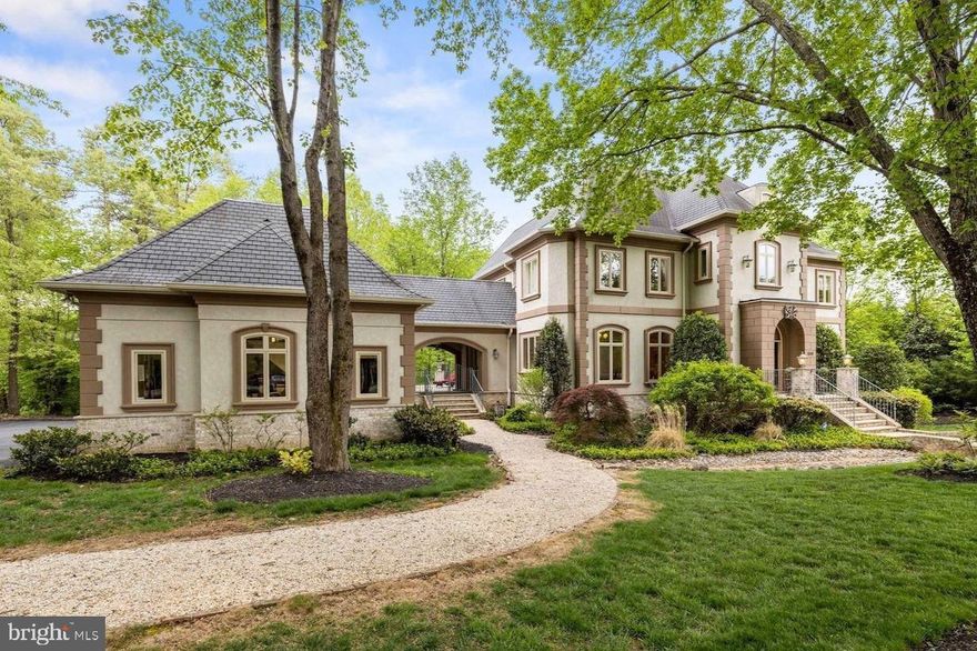 This truly extraordinary French Manor estate is set on two partially wooded acres at the end of a quiet cul-de-sac in the Kentland Farms community of Great Falls. Timeless in its architecture and executed with an uncompromising level of craftsmanship, the residence is defined by its scale, symmetry, and architectural presence—offering a level of finish rarely seen. At its center is a 5-bedroom, 5 full and 2 half bath main residence encompassing over 9,000 square feet across three finished levels, complemented by a beautifully executed carriage house—complete with its own kitchen, living space, bedroom, and bath—connected by a breezeway and designed to function as a fully independent residence.

The main level unfolds with a sense of architectural clarity and proportion, where a dramatic two-story foyer and sweeping staircase introduce a central hall of impressive width and proportion that anchors the home. Ten-foot ceilings, expansive windows, and an abundance of natural light create a sense of volume while maintaining warmth and definition in each space. Formal living and dining rooms are elegantly appointed and distinctly defined, while the kitchen is both substantial and inviting—featuring custom cabinetry, a large center island, and a natural connection to the breakfast room. From here, the home opens to the terrace, where stonework and surrounding landscape create a seamless extension of the interior, accompanied by the soft, natural sound of the creek below. The great room, centered around a floor-to-ceiling stone fireplace, and a private office complete the level with a sense of balance and intention.

Upstairs, introduced by the home’s sweeping staircase, the primary suite is a private retreat of impressive scale, with its own fireplace, dual walk-in closets, and a spa-caliber bath designed with both comfort and proportion in mind. Three additional bedrooms, each with en-suite baths, are thoughtfully arranged, along with an upper-level laundry room positioned for everyday convenience without disrupting the overall flow.

The lower level continues the home’s sense of scale, offering a walk-out recreation room centered around a third fireplace, a private fifth bedroom suite, an additional office, and a dedicated exercise room—creating a fully realized extension of the living space suited for both entertaining and daily use.

The carriage house carries the same architectural language and level of finish, with a fully self-contained residence on the upper level featuring a kitchen, living area, bedroom, and bath, complemented by its own dedicated garage bay. Connected by a breezeway, it maintains a true sense of independence—ideal for multigenerational living, long-term guests, or an au pair residence, with dedicated laundry located at the garage level.

The grounds are as thoughtfully designed as the home itself, set on a serene, wooded homesite with a gently flowing stream and quiet pond creating a private, natural backdrop—offering a setting that feels both secluded and enduring within Great Falls.

Kentland Farms is characterized by its expansive homesites, mature surroundings, and quiet, residential feel, all just minutes from Great Falls Park and the shops and dining of Great Falls Village Centre. The location offers access to highly regarded Fairfax County schools, including the Langley High School pyramid. Commuting is convenient with access to Georgetown Pike, Route 7, and the Dulles Toll Road, with proximity to Tysons, the CIA Headquarters, nearby Silver Line Metro access, and travel to Washington Dulles International Airport and Ronald Reagan Washington National Airport.

A residence defined by architectural integrity, scale, and setting—offered with a level of presence and refinement that is increasingly rare.