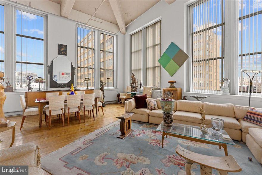 Welcome to the historic Beaux Art Loft Building located at 1238 Callowhill Street in the loft district of Philadelphia with quick and easy access to the highline and a short stroll to Chinatown and CC.
This is a once in a lifetime opportunity to obtain not 1, but "2" penthouse units. This spectacular unit spans the entire north side of the building and then down along the west side 2 window bays.... providing great views of the newly finished highline and great sunsets in addition the incredible northern light. Windows that reach 11' in height and ceilings that tower 18' with concrete, hardwood floors throughout, with marble and tiled baths and stone accents.
The main kitchen had granite counters and stainless-steel appliances. The guest kitchen is also outfitted with granite counters. This home was crafted to create a unique one-of-a-kind space. The current owner carefully blended 2 units together to create a home featuring a sumptuous, 740-sf primary suite with a sitting area, full bath and a walk-in closet. Down the hall into what was another unit totaling 1063-sf is now the oversized living room with wood burning fireplace, kitchen, a 2nd bath and the perfectly placed dining room for those sunset dinners. There are 2 zones of heat and air.  The building has just replaced the roof and created wonderful roof deck with multiple areas for lounging and dining.
Lofts this special don't come along often, so please come a take a tour.