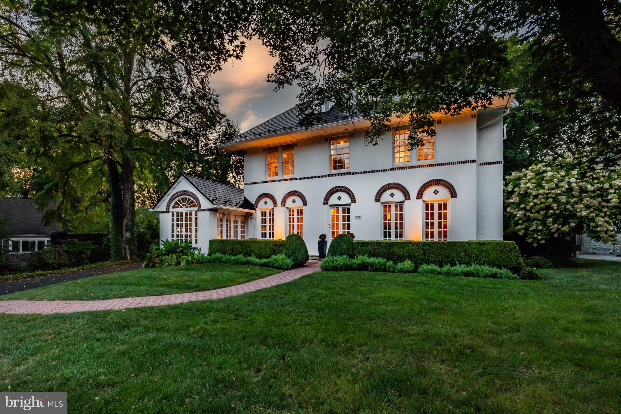 In a class of its own. Welcome to 205 Roberts Rd, one of the most beautiful homes in Ardmore, with its unique Mediterranean Revival style, offering a location within a short walk to Suburban Square and so much more. This stunning home features 5 bedrooms, 3.5 bathrooms and more charm than you’ll know what to do with! Pull up and immediately fall in love with the beautiful design details of this early 1900's home, rich with architectural characteristics everywhere you turn. The first floor has a wonderful flow to include a large and sunlit living room with 3 sets of French doors leading to the front porch, a classic fireplace, coffered ceiling and the original oak hardwoods in a beautiful honey tone. Off the living room is the sunroom, a great space for lounging or entertaining guests with it's heated floor and beautiful windows. The formal dining room has room for a larger table and server, also with French doors leading out front. The eat-in kitchen has a butlers pantry area with original cabinetry and makes a great party set up or coffee bar, maple cabinets, granite counters, stainless steel appliances including top of the line fridge, Wolf steamer, 2 tiered island with storage and a great breakfast nook with access to the back bluestone patio and private fully fenced backyard. The half bath is perfectly tucked away under the stairs. Use the front or back stairs to head on up! The primary suite is spectacular! The bathroom was recently renovated to include Antracita Porcelain tile from Spain, a Bocchi Contempo fireclay farmhouse sink which is designed in Italy, a bidet, heated flooring and the most chic shower in town! It’s truly one of a kind. The primary bedroom has plenty of closet space tucked away behind custom slider doors that tie beautifully to the bathroom. There are 2 more spacious and sunlit bedrooms on the second floor and another full bath. Up on the 3rd floor are 2 more bedrooms and a 3rd full bath with a claw foot tub and a great view of the picturesque property. The versatility of the floor plan is perfect for work at home, hosting guests or just the need for 5 bedrooms! The walk-out basement is clean as a whistle and thoughtfully updated to include new flooring, new sink and cabinet, the installation of a full glass door to let the light in, tons of storage cabinets added and parging of the walls make this a great space for working out, doing laundry or just nice clean storage. The property itself is perfectly private in the back, has a phenomenal 2 car detached garage with the original barn doors and a 2nd floor loft that can be converted into something magical. Entertain your guests on the patio, surrounded by lush landscape and a natural privacy screen. The current owners have poured love and resources into this home. A perma lock metal roof with a lifetime warranty, updated electrical and many other thoughtful upgrades make this a phenomenal value. This home gleams with old world detail, custom mouldings and is located in one of the best locations Ardmore, Lower Merion has to offer. Walk to Suburban Square in minutes and enjoy upscale shops, cafes, a farmers' market with easy access to the train. Enjoy live music at Ardmore Music Hall, a craft beer at Tired Hands or a movie at Bryn Mawr Film Institute. This home offers a lifestyle and location that you’ll never want to miss.