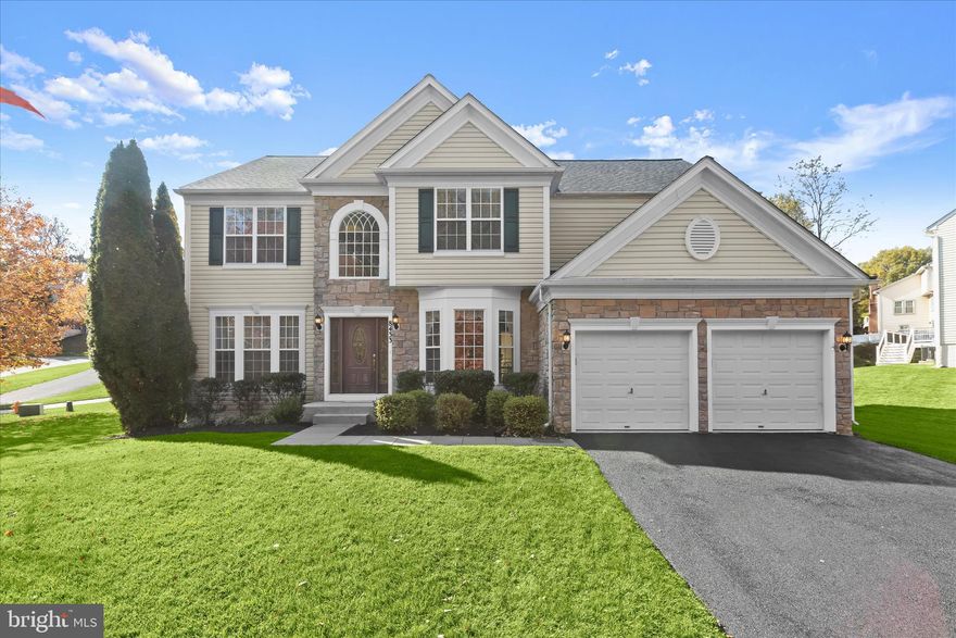 Stunning Colonial residence gracefully positioned on a premium lot in the sought-after Stonecrest Manor community, ideally situated across from protected land offering serene views. Freshly painted in a warm, modern white throughout the main and upper levels, this exceptional home boasts over 5,000 sq. ft. of luxurious living space and showcases numerous updates including the roof, luxurious primary bath, new carpet, deck, and more.  A striking stone-accented façade and Pella wood door enhance the curb appeal and sets the tone for what awaits inside.  A grand two-story foyer welcomes you in, framed by refined formal living and dining rooms accented with detailed molding and architectural columns. The dining room is highlighted by a spacious bay window that captures picturesque views of the protected woods beyond. Rich hardwood flooring flows seamlessly into the breathtaking two-story family room, where a floor-to-ceiling gas fireplace creates a stunning focal point and an inviting gathering space. The open layout transitions effortlessly into the gourmet kitchen and sun-filled breakfast room with direct access to the expansive deck.  Designed for both entertaining and everyday living, the kitchen features an oversized island with breakfast bar and gas cooktop, stainless steel appliances, and beautiful wood cabinetry. A private home office, powder room, and laundry room complete the thoughtfully designed main level.  Upstairs, the impressive primary suite offers a grand retreat with a tray ceiling, generous walk-in closet, and a beautifully updated spa-inspired bath featuring a soaking tub, oversized frameless shower with designer tile, private water closet, and an extended dual vanity spanning the full wall length. Three additional spacious bedrooms and a full bath complete the upper level.  The finished lower level expands the living space with extra-wide stairs leading to the backyard, a large game and recreation area, full bath, and abundant storage. Outdoors, enjoy the expansive composite deck with pergola overlooking the cherry blossom trees in the professionally landscaped grounds.  A spacious two-car garage and oversized driveway provide ample parking. Ideally located near major commuter routes, as well as premier shopping, dining, and entertainment, this exceptional home blends timeless elegance with modern luxury in a highly desirable setting.