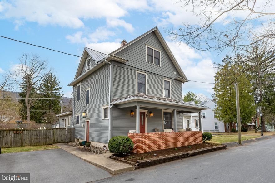 Rich in charm and character this residence in desirable Historic Boalsburg will embrace you. The kitchen boasts beautiful fire slate countertops, stainless steel appliances, and plenty of counter space for all your culinary needs. Rich hardwood floors flow seamlessly through the dining and living areas, where expansive windows create a bright, airy ambiance. The family room is highlighted by a cozy wood-burning fireplace and opens to a sweet porch, complete with a fenced-in outdoor space for added privacy. New residents will also appreciate the garden area, which includes a well-established asparagus patch.  Upstairs, you'll discover three generous bedrooms with hardwood floors and a full bathroom. The third floor features a versatile room with a spacious walk-in closet, soaring vaulted ceilings, and exposed brick walls, infusing the space with distinctive charm. The lower level is fully equipped with a laundry area and offers ample storage space. Enjoy the convenience of being just a short walk to quaint shops, tasty restaurants, coffee shop and more. Additional parking is available in the alley.