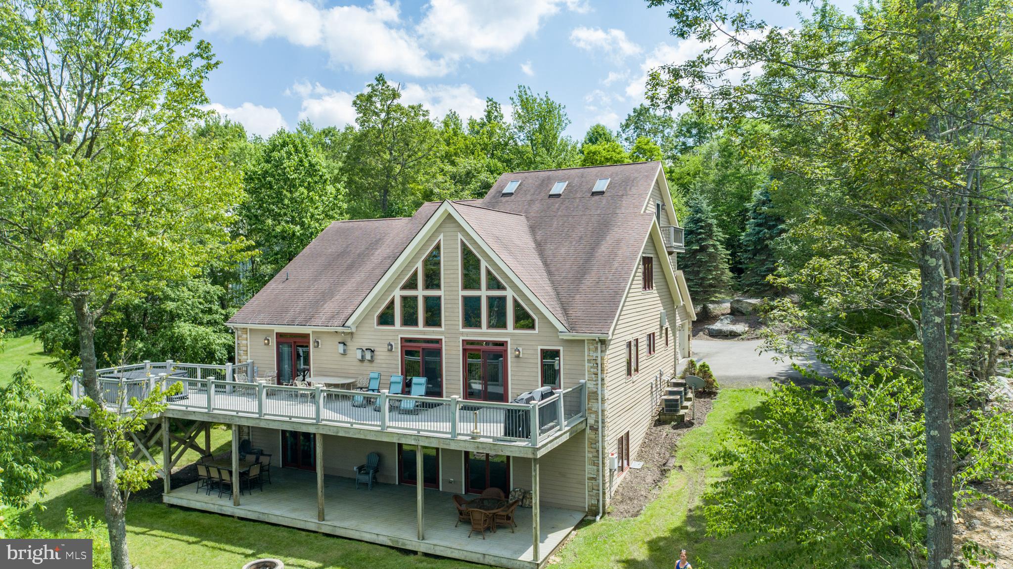 Elegant Craftsman tucked at the end of a private cul-de-sac in Deep Creek Highlands! 7 bedrooms with 5 and 3 half baths. Thoughtful layout across three finished levels. Commercial-grade Vulcan appliances anchor a sharp, open kitchen. Walk-out basement with full game suite. Fresh flooring. Updated furnishings. Three fireplaces. Two spacious stories of outdoor decking with sweeping views of Deep Creek Lake. Private hot tub. Flat yard with a fire pit. Oversized garage. Paved circular drive. Gated community with pool, tennis, trails, and pavilion. Minutes from Wisp, marinas, and state parks—close to the action, removed from the noise. An established vacation rental, “Above it All” is being sold turn-key fully furnished. Call today for details!