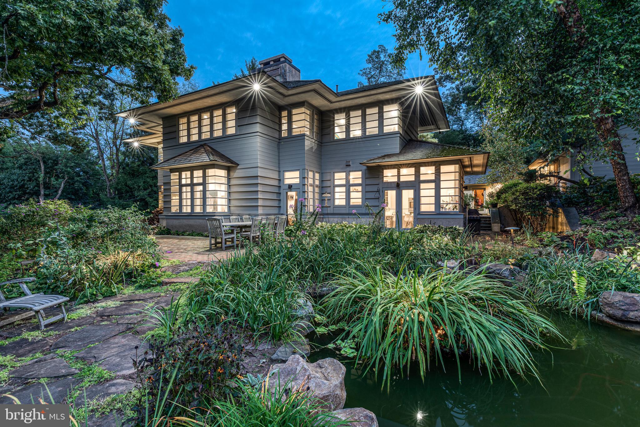 This spectacular home with a detached two-car garage is nestled on 2.15 acres, situated alongside Wissahickon Valley Park. The location is not to be believed. On the property is an equally well-designed guest house which we will describe in further detail below. Drive up to this dream location at the end of Northwestern Avenue through a gated entrance. On the main floor, the newly renovated kitchen boasts an oversized island with seating, custom Bulthaup cabinetry and countertops, abundant pantry storage, and Bosch appliance suite including a 6-burner range, hood vent, double oven and a built-in refrigerator and dishwasher. The adjoining dining area and open living area features vaulted ceilings and a wood burning fireplace. There are views of the lush landscaped grounds, designed with special blooms in mind for every season. It is green as far as the eye can see. This floor is complete with an ensuite, a 2-story foyer and a powder room. Upstairs the master suite with vaulted ceilings, wood fireplace, built-in cabinets, and walk-in closet is nestled along the tree line with more incredible views. The bathroom features a large soaking tub, a glass-enclosed shower and two separate water closets with vanities. The 2nd floor is complete with another spacious bedroom and 4th bedroom/nursery/office. The newly finished basement allows more living space in the home you'll never want to leave. Currently set up as an entertainment room. The laundry room with barn door and shelving is tastefully appointed. Outside enjoy the slate patio, a magnificent koi pond and several tiers of landscape, beyond which the hills roll into the Wissahickon Valley Park. The guest house details: built in 2018 and features a new kitchen with quartz countertops and stainless steel appliances, a spacious bedroom with vaulted ceilings and bathroom with a double sink, floating vanity and a glass enclosed walk-in shower. It also has sliding glass doors leading to a crushed stone patio overlooking the lush green landscape. **The # of bedrooms and bathrooms includes the bedroom and full bathroom in the guest house. The guest house is 840 sq ft. The property has a Phila zip code but is located in Springfield Township.