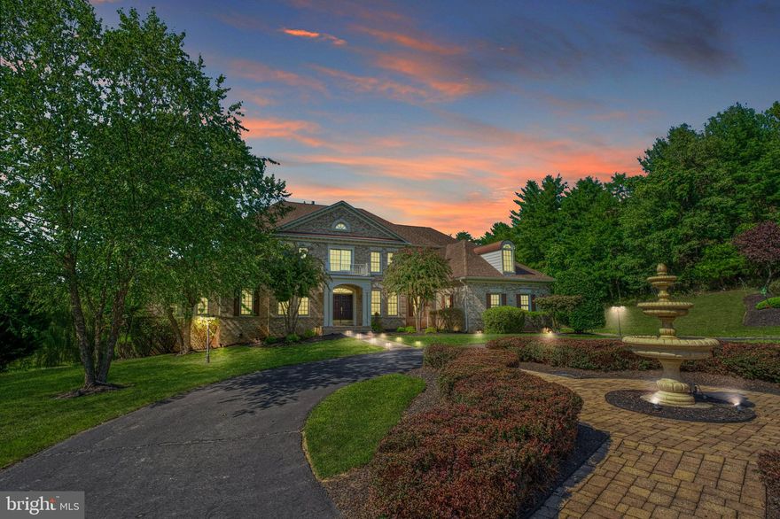 Overlooking 3.89 private acres in distinguished Beacon Hill, this beautifully constructed 9,214 square foot residence offers a seamless blend of indoor and outdoor living, ideal for both sanctuary seekers and entertainers alike. From within the brick-wrapped facade, overlooking a stately circular drive, a rarely seen two-story solarium invites natural light and a place for horticulturalists and sun-seekers to linger, while the home’s living and entertainment spaces welcome with soaring ceilings, elegant custom moldings, and striking showcase chandelier. Complete favorite recipes in the gourmet kitchen or let your favorite caterer complete bites within the expansive lower level’s secondary full-kitchen. Here, complete routines in the gym, mix drinks at the handsome wood-clad bar, host screenings in the theater, or head outside where lush grounds dotted with spring-blooming fruit trees shade a resort-worthy pool, expansive deck, stone-lined hardscapes, and strolls to nearby walking trails. Six sunlit bedrooms and six-and-a-half baths include a main-level suite - ideal for quiet escapes and multigenerational living. While on tour, visit the elegant dining room and note endless custom built-ins providing ample space and architectural interest. From home, historic downtown Leesburg, Wine and Hunt Country, commuter routes, and entertainment destinations await, just moments away.