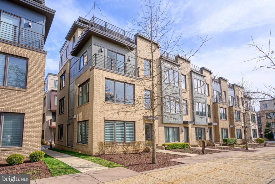 In one of Montgomery Row's finest locations overlooking the Community Park, this generously-sized 4-level, end-unit is finished with high-end materials and custom appointments throughout creating a gorgeous, welcoming home. Built by EYA in 2017 with more than $150,000 in upgrades, it's a home for modern living with flexible spaces, such as the entry-level bedroom/office suite and the 4th-floor loft /  family room (optional 5th bedroom) with wall of windows, full bathroom and another closet. Everywhere, you look are quartz countertops, oak hardwoods, custom rugs, Hunter-Douglas blinds and upgraded light fixtures. The open floor plan on the main level is ideal for entertaining with a built-in sound system, a striking white kitchen,  gas fireplace and gleaming chandelier. The primary suite offers dual bathroom sinks and a custom-organized walk-in closet. The roof terrace off the family room is an urban oasis with a gas fireplace and contemporary finishes. The 2-car garage (serving as an in-home gym!) has plenty of storage with built-in shelving and organization system.  Quietly tucked amongst office complexes, the community parking is permitted, ensuring spots for guests. Additional parking is available in the adjacent office garage. Easy access to shopping, restaurants, downtown Bethesda, 270, & 495. Low HOA fees.