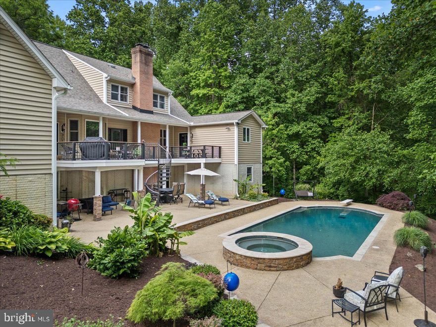 Tucked away in a setting of complete privacy, this captivating residence is a rare offering where charm, craftsmanship, and thoughtful upgrades come together effortlessly. Meticulously maintained and curated with intention, every space tells a story—one of quality, comfort, and timeless design. From the moment you enter, the home reveals its character through exquisite details: custom built-ins, carved wood ceilings, and beautifully refinished hardwood flooring that flows throughout. The heart of the home is both inviting and refined, anchored by a striking Wolf stove and complemented by a cozy fireplace and soaring vaulted ceilings. Designed for both everyday living and exceptional entertaining, the main level features two full baths, including a serene primary suite that offers a true retreat. Upstairs, you’ll find a private bedroom with its own en-suite bath, along with two additional bedrooms—one thoughtfully designed with a hand-painted forest mural, creating a whimsical and memorable space. Adding to the property’s versatility is a finished garage with a dedicated studio/workspace and a complete guest suite above, offering a full bath, bedroom, and separate work area—ideal for extended stays, creative pursuits, or private accommodations. The lower level has been recently finished, providing additional living space with a bedroom, expansive recreation or fitness area, and a convenient half bath with direct access to the outdoor amenities. Step outside and experience a true resort-like setting. The saltwater pool, just four years old, features a PebbleTec finish and a built-in spa, surrounded by extensive landscape lighting and color-changing pool illumination—creating an atmosphere that transitions seamlessly from day to evening. Ample parking and a large storage building ensure both function and convenience. Located less than an hour from Washington, D.C. and Annapolis, Maryland, this property offers the perfect balance of seclusion and accessibility. A private retreat of uncommon quality—designed to restore, inspire, and elevate everyday living.