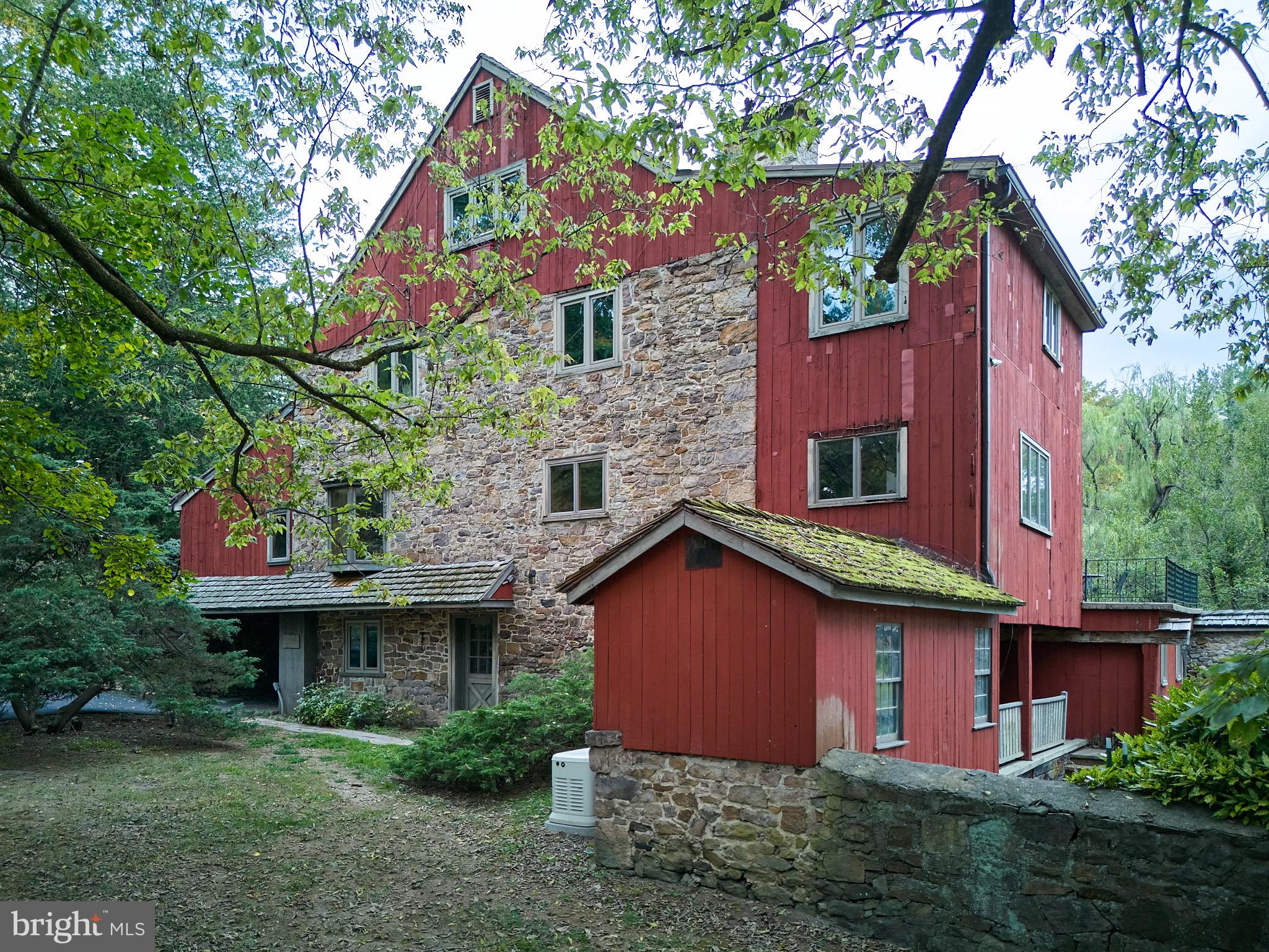 Welcome to Stone Barn, a classic Bucks County stone and frame bank barn built in the early 1800s. Converted to a residence around 1980, this extraordinary home is on the market for the first time in over 40 years. Expansive spaces, soaring ceilings, exquisite old beams, trusses and stone walls create stunning living spaces and offer many opportunities for a new owner to create their dream home. With four levels, the possibilities are endless. The main level features a gracious entry into the large living area with gorgeous random-width chestnut floors, a wall of windows and sliding glass doors to the terrace, and a stone chimney wall with raised hearth. Off the entry area is a tavern room, with a wet bar, which is a more intimate space with many possible uses including as an office, a library or play room. The expansive dining room can accommodate large dinner parties and has a sliding glass door to the terrace that overlooks the grounds and the stone-walled courtyard area below. The kitchen, breakfast area, a mudroom with stone floor and a powder room complete the main level. Up a flight of stairs the U-shaped second level has a cozy loft with stone walls, the main bedroom suite with a large full bath, a walk-in closet and more of the beautiful old architectural details. There are two additional bedrooms and a full bath on this floor. Up another flight, the finished third floor has three bedrooms, a full bath and generous storage spaces. The lower level, reached through a door off the entry area, is finished, with four rooms, including one with a brick fireplace, as well as a workroom, a utility room and a room that is rough plumbed for a bath. There are two doors to the courtyard, one opening on to a covered porch. The lower level offers nearly unlimited possibilities for a new owner! Located just north of vibrant New Hope, Stone Barn has easy access to commuter routes, shopping, recreation activities including walking, hiking, kayaking, and boating, as well as dining and cultural venues . It is 3.5 miles to the center of New Hope; 66 miles to the Holland Tunnel; and 42 miles to Center City, Philadelphia.