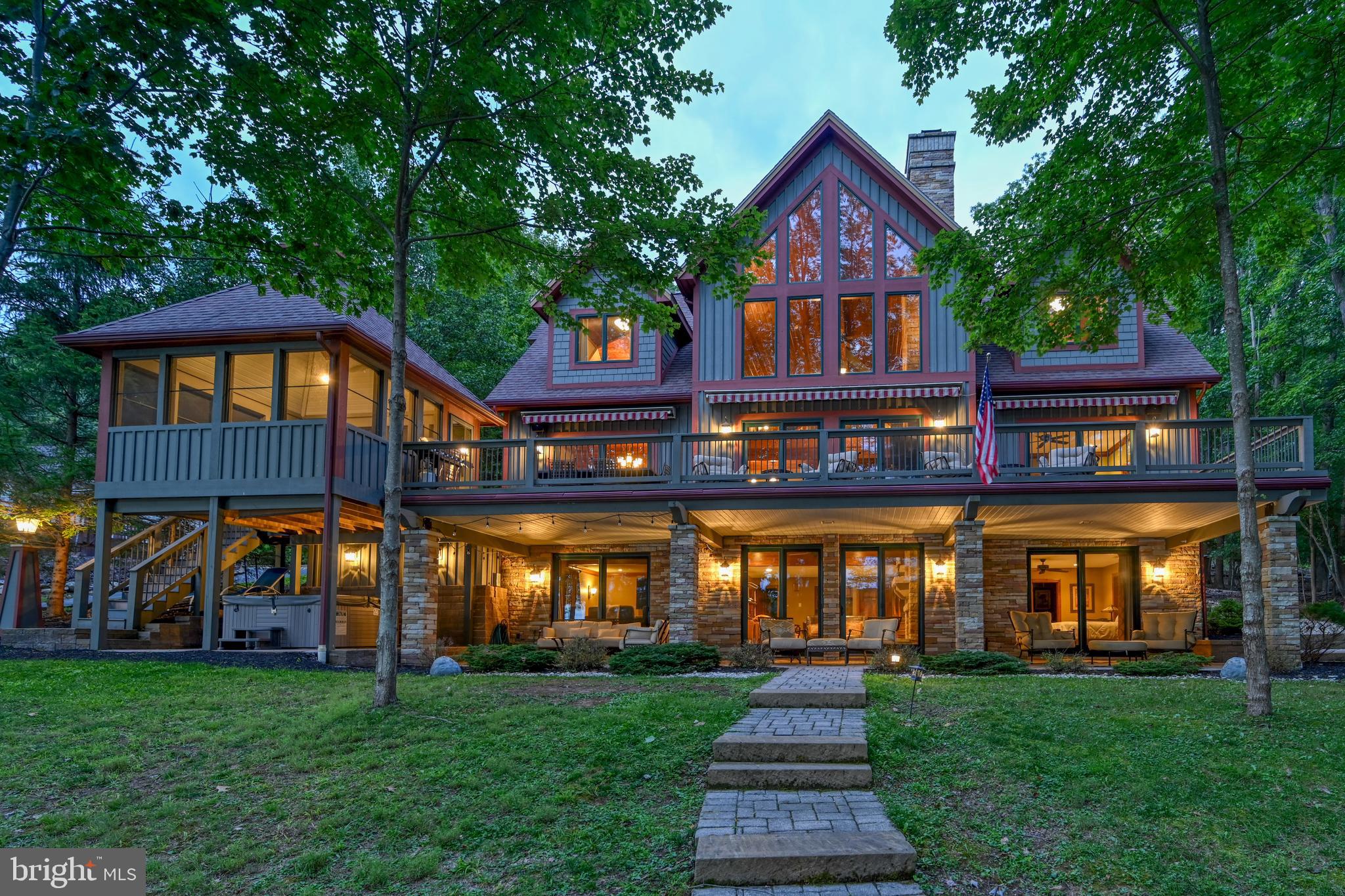 Deep Creek Lakes, Sunset Hills, luxury retreat offering majestic mountain & lake views. A unique lakefront property that plays a perfect host to relaxing vacations with family and friends is a low-key lifestyle centered around the outdoors. Vast stretches of glass ensure a sparkling water view is always on hand. Though sleek materials and high-end finishes abound, their low-profile design puts the spotlight where it should be on the stunning natural beauty of the location. Private oversized dock with two slips and a personal watercraft pad on deep water with 100' of the best lakefront at Deep Creek. Explore 65 miles of shoreline from the water or grab a deck chair and enjoy a clear view of the sun’s path from dawn to dusk. An established Vacation Rental too providing an excellent opportunity to supplement expenses. Envision yourself on the deck of this stunning lakefront home; basking in the sun and becoming mesmerized by the stunning sunsets. Sunset Hills will welcome you in with a sense of warmth and elegance, rain or shine. The spacious enclosed and open decks are perfect for soaking up the sun, enjoying your fresh cooked meal (made in the equally impressive kitchen), or just enjoying the fresh morning mountain air. The hot tub and lower patio area are great for lounging around after a day on the lake when it is still too beautiful to go inside. On those rainy days, gather in the theater room for a movie or battle it out in a game of pool. Wind out any day by falling into any of the five-bedroom suites (six counting the carriage house) with plush beds for a great night’s sleep before starting fresh the next day. Campfires by the lake, relaxing days on the deck, exciting days on the water, and cozy rainy day movie marathons. Let's not forget the location is within minutes of The Wisp, several golf courses, state parks, restaurants, and other favorite amenities. Lastly, the carriage house / oversized garage, provides plenty of storage and a fully functional living area too. A wonderful lifestyle investment in mountain-lake living.