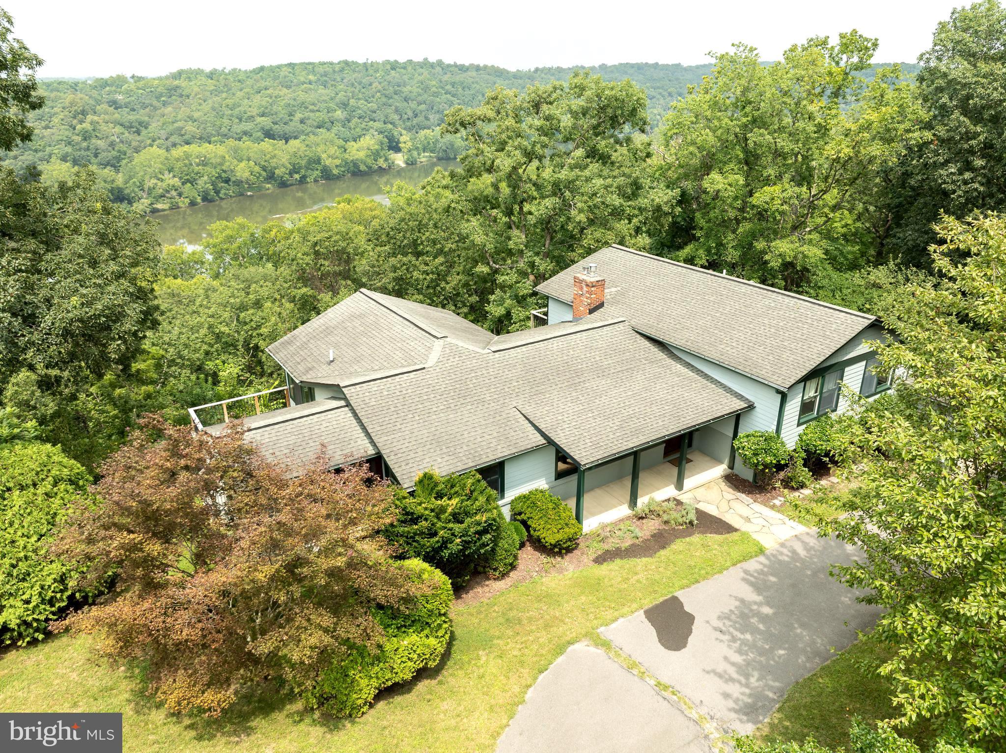 Welcome to this unique 2,590 sq ft split level home , offering Scenic River and Mountain views , located on a private wooded lot just minutes from Historic Harpers Ferry. Home has been well-maintained by same owners for over 20 years , and thoughtfully remodeled in 2008 by custom builder. The property welcomes you through a front gate and onto a circular driveway surrounded by mature trees . Step inside to find a light filled main floor with multiple open entertaining spaces. The heartbeat of the home is a bright Morning room/Sun room with striking cathedral ceiling and 12 massive casement windows which bring the lush outside of nature inside. The fantastic views include the Shenandoah River , vegetation/trees, the hill on the other side of the river and distant mountains. There are occasional eagles and migrating birds passing by to enjoy. The morning room has a slider door onto an easy care composite deck . The spacious kitchen offers upgraded appliances and cabinets and a 15 ft counter with pass through into the morning room. There is also a special drinking water faucet providing water that has been treated by a UV light and filtered by an additional system under the sink. The family room features a custom arts and crafts style gas fireplace with mantel and colorful tiles from Vermont. There is also a traditional living room, and a dining room or office with exit onto a screened in cedar porch with ceiling fan. The upper split level offers a spacious owners suite with a river facing private balcony. The attached bath is elegant with black and white tile flooring and the closet. . The other two bedrooms are also ample and also with closets and share a hall bath with double vanities. There is an additional closet in the hallway. The lower level can function as another entertaining space or a guest suite. The central den features a brick wall with wood stove insert. There is an exit door to a river facing deck which directs you to the rear patio. There is another exterior door to provide access to the 1 car garage via a small covered porch. Also inside the guest suite, you will find a full bath , a breakfast bar with sink, , and small eating space, plus another room with closet and egress that could be used as another sleeping area. There is a door with stairs down to the large , open basement which provides easy access to the mechanicals, including but not limited to, a new 3 zone HVAC system, UV light and passive radon system.
The exterior has been professionally landscaped and the perimeter is encircled by a split rail fence to protect the pets and children, and the terraced side yard is enhanced by stonework accents.
The community does not have an HOA but rather a Civic Association. There are required road maintenance fees priced according to the lots. There is an optional $400.00 fee to join the Association for amenities, such as use of the pool and clubhouse and access to the community river front picnic area with boat launch. Plus, Comcast is available. Harpers Ferry is a popular area offering many recreational activities, historic venues and easy access to commuter routes to Maryland and Virginia - approximately 45 minutes to Dulles Airport.