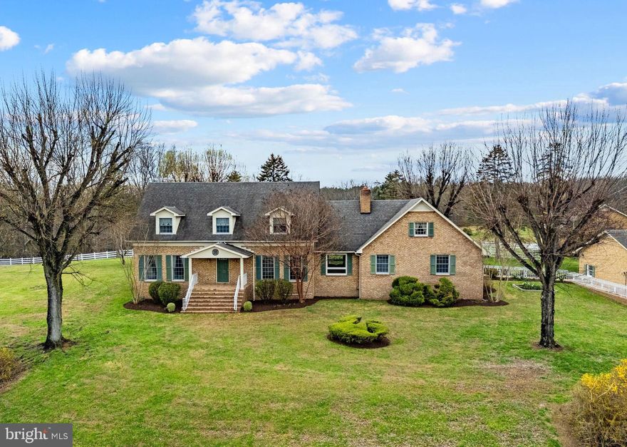 Welcome to Elysian Fields Farm, a magnificent 56+ acre equestrian estate situated at 456 Marple Road in Winchester, VA. Spanning three distinct parcels and located just 10 minutes from the conveniences of town, this private retreat is defined by its timeless brick construction and a masterfully designed layout that harmonizes luxury living with top-tier agricultural infrastructure. The arrival experience is nothing short of grand, featuring a long, winding paved driveway framed by stately brick pillars and secure automated gates that lead over a private bridge above a serene, meandering stream. The rolling pastures and picturesque pond are secured by low-maintenance vinyl rail and extensive cross-fencing, all protected by a dense perimeter of mature hardwoods for ultimate seclusion. The main residence stands as a testament to enduring quality, showcasing superior solid-brick craftsmanship and meticulous attention to detail throughout its sprawling footprint. The main level features gleaming hardwood floors throughout the formal living and dining rooms, both of which are bathed in natural light from floor-to-ceiling picture windows. While the home offers a sophisticated and polished atmosphere, the true heart of the home is the breathtaking, two-story family room, which boasts soaring wooden vaulted ceilings with exposed beams and a dramatic two-story brick fireplace with a cozy gas insert. The kitchen offers a warm, refined aesthetic with rich, cherry-toned cabinetry, stainless Whirlpool appliances, and a central island with seating. For additional entertaining space, a massive bonus room/den offers durable tile flooring, built-in shelving, a second impressive brick fireplace, and direct access to an expansive rear brick patio overlooking the flat, park-like yard and pastures. This level is completed by a bright bedroom, a full bath with double sinks, and a convenient laundry room. The upper level, which also features hardwood flooring throughout, houses the primary suite with a private ensuite bath, alongside two additional bedrooms and another full bath. The estate’s exterior is a triumph of functional luxury, defined by its expansive, well-managed acreage and professional-grade outbuildings. The equestrian centerpiece of the property is a large brick barn meticulously framed by white fencing; this multi-purpose facility features heavy-duty horse stalls with durable block construction and rubber mats, a dedicated workshop, and equipment storage space. Additionally, the barn includes a full bath and a flexible extra room—ideal for a private office, studio, or tack room. The surrounding landscape consists of lush, verdant pastures designed for optimal grazing and ease of rotation, further enhanced by a practical run-in shed positioned in the distance for field-kept livestock. Whether you are an avid equestrian or seeking a multi-generational family compound, this well-manicured estate offers the rare combination of architectural cohesion, functional farm utility, and serene country privacy.