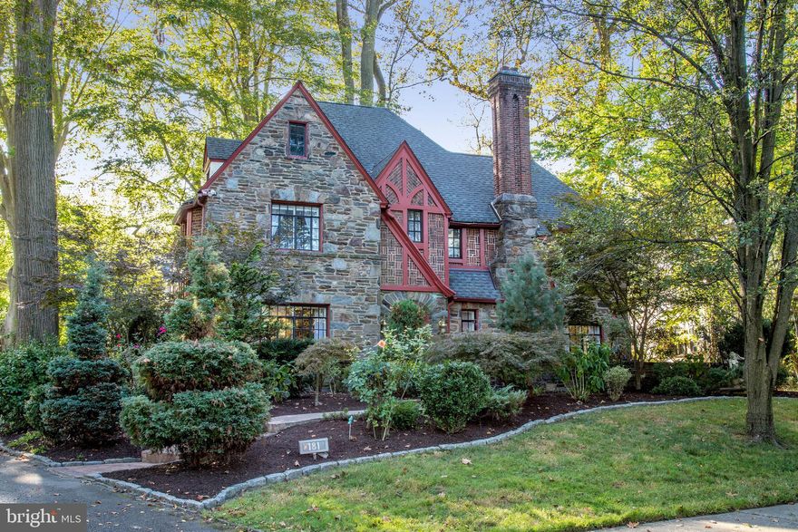 Live in a piece of Ardmore history at this exquisite Tudor masterpiece sited on a gracious flat .25 acre lot  enveloped with mature trees and lush landscape. The 4 bedroom, 3.5 bath storybook family dream home provides a stately yet charming English feel with its exquisite stone exterior, distinctive architectural elements, and dramatic Tudor-style touches throughout. Among these are a classic wood staircase in the airy entry foyer, elegant open archways, beautiful crown moldings, and gorgeous hardwood floors throughout. The light and airy interior affords an effortless flow for living and entertaining, anchored by the gourmet kitchen which is outfitted with tile flooring, sleek granite countertops, stainless steel appliances, a sunny breakfast nook, decorative tin ceiling, tiled backsplash and floor tiles with a lovely medallion accent. For intimate gatherings, the formal dining room just off the kitchen offers a welcoming space to host with a sparkling chandelier and ornate ceiling medallion. In the formal living room, a marble fireplace and picture windows set an inviting tone, with glass doors to the outdoor oasis. A cozy den with built-ins is a perfect place to relax. On the second level, all of the bedrooms come oversized with ample closets and well-appointed baths featuring a thoughtful mix of modern upgrades and period accents. An unfinished vaulted attic provides endless possibilities for storage and additional use of space. The generous day-lit basement also affords options for finishing and houses a laundry room with large utility sink. Outside, you'll enjoy a tranquil secluded feel with an inviting stone patio, mature flowerbeds, and enchanting pathways for taking in some fresh air. A long drive leads to a built-in 2-car rear garage for your vehicles. Ideally located on a quiet block in a sought-after Main Line neighborhood, this property is truly a rare find! Experience the attention to detail and serene lifestyle of this immaculate Ardmore gem.