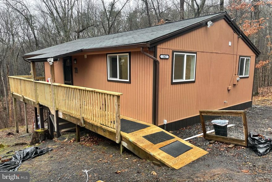 Super nice cabin in the woods with lots of recent updates! Offers 2 bedrooms and one bath, has replacement windows and sliding glass door, newer washer, dryer and stove, recent kitchen and bath updates, newer HW heater, has new Luxury Vinyl Plank flooring throughout and new PEX pipe plumbing with transferable warranty, deck was refurbished and inside and out recently painted. MOVE IN READY! Energy Efficient Mini split (basically a ductless heat pump) was installed 9/18, has Electric Baseboard backup and offers a wood burning fireplace. Sweet little part time get away or full time home. Best of all...this one backs to Sleepy Creek Wildlife Management area which offers close to 23,000 acres of preserved land for hunting, fishing and other outdoor adventures. The Community offers a 5 acre Spring-fed Lake with dock and beach great for fishing, canoeing, kayaking and swimming. It also has a baseball field and Pavilion. It is approximately 12 miles away from Historic Berkeley Springs and just a few miles from The Woods Resort. Come take a look! More pics to be added by end of day 1/22.