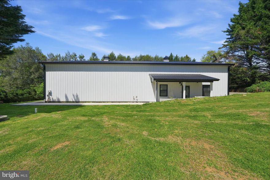 Where versatility meets scale—this one-of-a-kind barndominium redefines what residential living can be. Offering an extraordinary blend of industrial space and finished living, this 4,000 sq ft structure is split between expansive garage/workshop capacity and thoughtfully designed residential quarters, all under one cohesive roof and already granted a Certificate of Occupancy as a residence. The garage level features soaring 16-foot ceilings throughout and a 14' x 12' wide door, creating an unmatched environment for car enthusiasts, contractors, collectors, or anyone needing serious space to build, store, or create. A convenient half bath serves the workspace, while wide-open spans allow for endless configuration possibilities. Step into the residential side and you’ll find a dramatic open-concept main living area with equally impressive 16-foot ceilings, concrete floors, and a loft-style feel that blends modern minimalism with industrial edge. The kitchen and great room flow seamlessly as one expansive gathering space, designed for both everyday living and entertaining on a grand scale. The main floor also includes a private bedroom, full bathroom, laundry room, and flexible office spaces ideal for remote work, studio use, or guest accommodations. Upstairs, the second floor is already framed and ready for transformation, with rough plumbing in place for two additional bedrooms and two full bathrooms—offering a rare opportunity to expand finished living space without starting from scratch. Set on a well and septic system sized for a three-bedroom home, this property is fully functional while still offering significant room for customization and growth. Whether you're envisioning a live/work compound, a collector’s showcase home, a multi-generational setup, or a fully customized luxury conversion, this property delivers a foundation as rare as it is adaptable. Endless potential. Immediate usability. Unmatched scale.