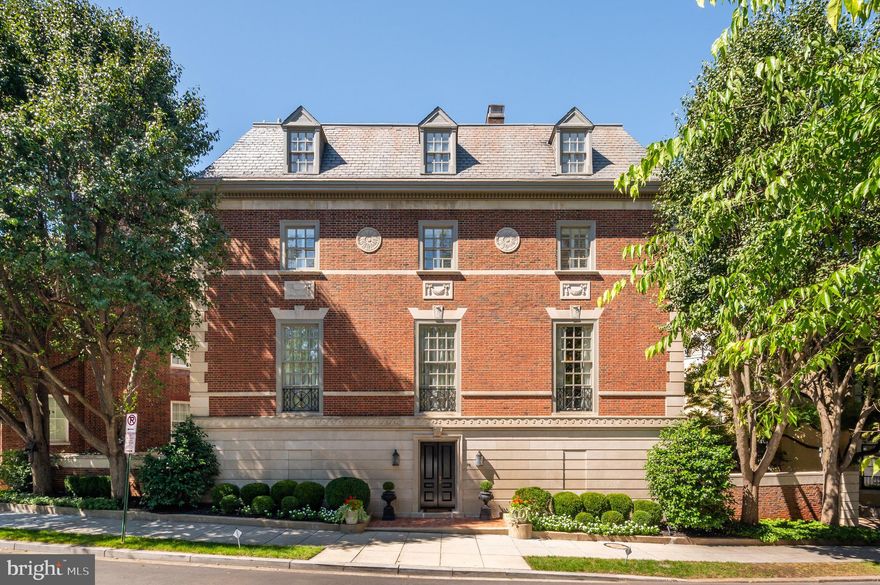 Prominently situated on revered Kalorama Circle, directly adjacent to the French Ambassador’s residence, is number 78. A Neo-Palladian Revival residence constructed at the height of the Roaring 20s and painstakingly restored over the years. A stately, symmetrical facade, honed from limestone and brick, is sparingly embellished by cornice work and rosettes, creating a subtle elegance while harkening back to a bygone era of master craftsmanship. The restrained entrance reveals an elegant gallery-style greeting hall, with gleaming inlaid marble floors and accent lighting converging around the dramatic central staircase spanning all four levels, bathed in natural light from the large skylight above. A private office, access to a shady pea gravel sculpture garden, glass-enclosed wine room, and staff quarters are thoughtfully positioned on this level.
 
The main level’s effortless flow is enhanced by towering ceilings. Here, embassy-sized formal spaces are clad with parquet flooring and intricate plasterwork, enabling entertaining on a level of grandeur reminiscent of Washington’s Gilded Age. Fireplaces in both formal living and dining rooms add warmth and anchor these elegant spaces, while a private library is discreetly tucked away with access to the rear terrace. The contemporary chef’s kitchen is a refreshing contrast: sleek European-style cabinetry and a full complement of professional-grade stainless steel appliances are centerpieces of a space that can be fully opened to the outdoors.
 
The principal suite occupies almost an entire level. A sitting area with a fireplace and integrated bookshelf is an artful addition to the oasis, served by two sumptuous baths and dressing rooms. A sunroom boasts verdant wraparound views of leafy treetops and neighboring gardens via panoramic windows. The scenic vista is also shared by the top level’s observation deck. A central family room is flanked by two spacious bedrooms, each featuring a luxurious ensuite bath. An oversized, attached garage and a large, private motor court complete the offering. Stunningly authentic yet inventively modern, 78 presides as one of the great homes of Kalorama, one of the city’s most established neighborhoods and unquestionably one of Washington’s premier offerings.