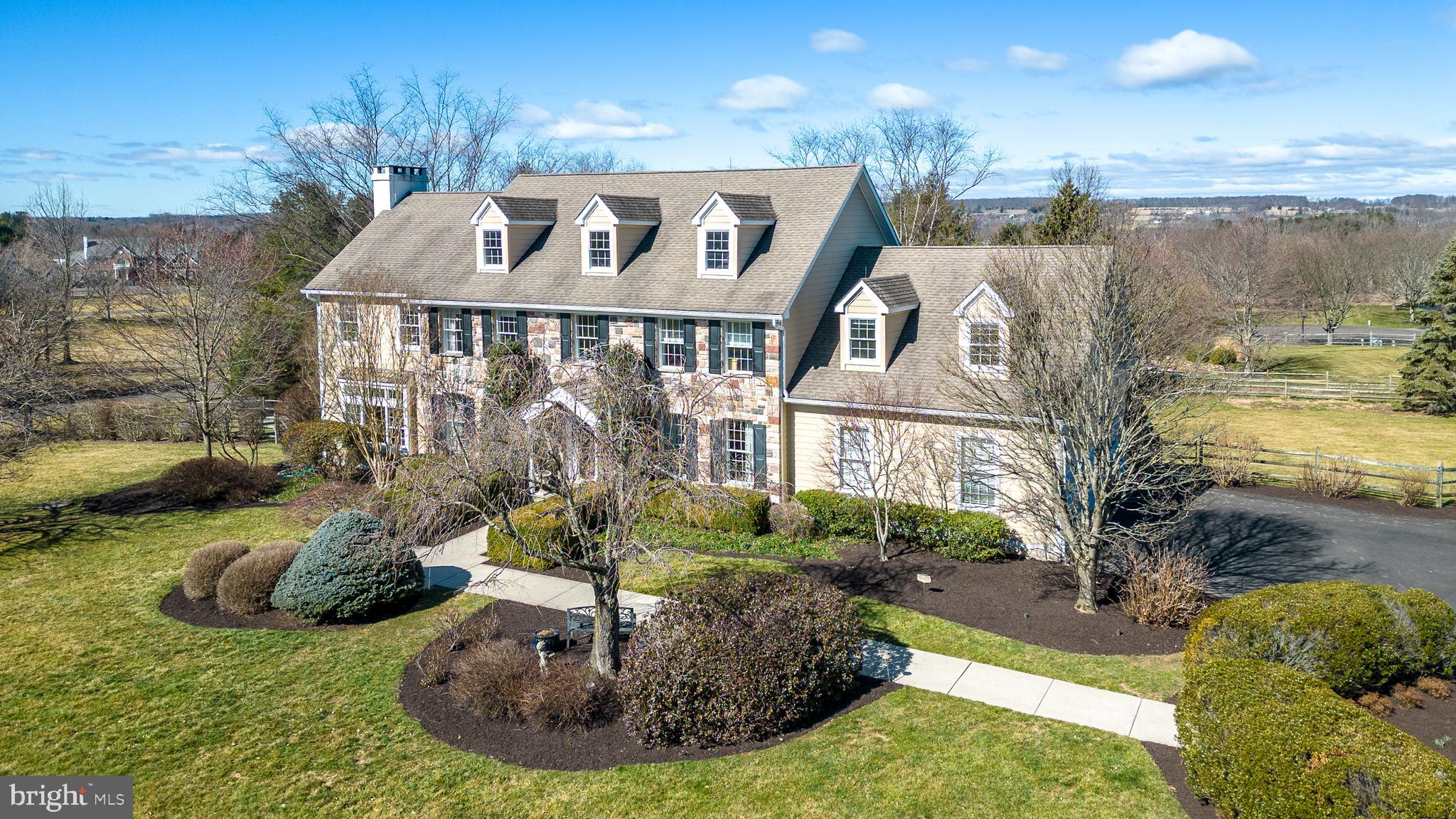 Just outside the historic village of Carversville is Tamarack Farms, a beautifully-designed community of custom homes arranged around a small private park and surrounded by more than 180 acres of preserved land. 37 Magnolia Ct sits on a large corner lot with professionally-landscaped grounds and a truly gorgeous heated swimming pool and spa. The two-story foyer sets the tone for the classic layout of the home, custom-built by Peter Edwardson, with a central staircase, a formal dining room to the left and a parlor/study with beautiful french doors to the right. Straight ahead is the spacious kitchen, designed by Charles Weiler, with high-end stainless steel appliances, custom hardwood cabinetry, Bucks County soapstone countertops, pantry, and a large granite island bar with seating in the center. Adjoining the kitchen is a sunny breakfast room with three walls of windows, double glass doors to the raised Trex deck, and beautiful views of the expansive backyard. The sunken family room with its floor to ceiling stone fireplace is a great gathering spot for both family and guests, and there are glass doors to the deck here as well. That, coupled with the home’s thoughtful design and easy flow, make the property an ideal home for year-round entertaining. Rounding out the first floor is a service area off the kitchen that offers a powder room, additional pantry space, a mudroom/work area with great storage, and easy access to the oversized, 3-car garage. Upstairs, the primary suite features a spacious bedroom with cathedral ceiling, a large bath with both a spa tub and a walk-in glass shower, and double vanities. Additional space off the primary bedroom features a walk-in closet and a sitting area big enough for TV-viewing, a home office, or both. At the other end of the second floor is an updated hall bath, along with four additional bedrooms, one with its own ensuite bath, a dedicated laundry room (with custom cabinetry and sink), and a second staircase that leads back down to the living area. The finished basement includes a full bath, a home gym area, a family room, a wet bar, and a game room. Double glass doors that open to the back patio provide easy access to the pool, and large windows give the whole space a bright, open feel. A separate unfinished area includes a utility sink and plenty of space for extra storage. It’s only a five-minute drive to the Delaware River, with easy access to all the fine restaurants and shops that Bucks County has to offer, plus an easy commute to New Jersey: just ten minutes to the Stockton Bridge and a little over 30 minutes to Princeton. Numerous additional features include: beautiful hardwood floors, transom windows and custom millwork throughout, 14KW house generator, whole house UV water purification, new exterior Royal Celect Siding, large attic suitable for finishing, landscape lighting, new pool heater, newer pool tile and coping, fully fenced backyard, fire-pit area, large backyard storage shed. NEW HOPE – SOLEBURY SCHOOL DISTRICT.