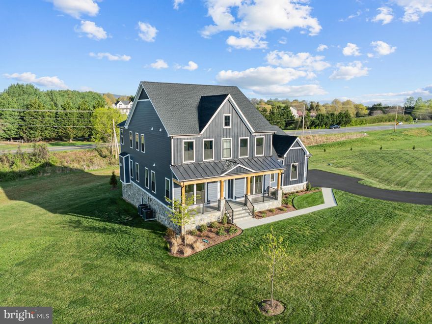 Experience refined living in this exceptional Van Metre Timberneck III, perfectly sited on just over 3 acres in the Glenmore Farm community of Waterford. Built in 2024 and enhanced with thoughtful post-construction upgrades, this home offers more than 6,250 finished square feet across three beautifully designed levels, combining elegance, comfort, and functionality.

From the moment you arrive, the inviting front porch sets the tone for what awaits inside. The main level features soaring 10-foot ceilings, a light-filled open layout, and carefully defined spaces that balance everyday living with effortless entertaining. The great room is anchored by a striking fireplace, while a private study provides an ideal work-from-home setting.

At the heart of the home, the gourmet kitchen impresses with upgraded cabinetry, quartz countertops, stainless steel appliances, a full quartz backsplash, 5-burner gas cooktop, an expansive center island, and a walk-in pantry designed to blend style and practicality.

Upstairs, the luxurious primary suite serves as a true retreat, complete with a tray ceiling, a spacious walk-in closet, and a spa-inspired bath featuring dual vanities, a frameless glass shower with built-in seating, and a freestanding soaking tub. Three additional bedrooms, two full baths, and a conveniently located upper-level laundry room complete this level

The fully finished, bright lower level expands the home’s versatility, offering a dedicated theater room, a separate fitness room with gym equipment that conveys, a generous recreation area, a fifth bedroom, and a full bath that easily accommodates guests, relaxation, and entertainment.

Surrounded by the scenic beauty of western Loudoun, Glenmore Farm offers a peaceful, estate-style setting with expansive homesites and picturesque views, all just minutes from the historic village of Waterford and downtown Purcellville.

This is a rare opportunity to own a nearly new luxury home with acreage, premium upgrades, and exceptional livability in one of Loudoun County’s most desirable communities.