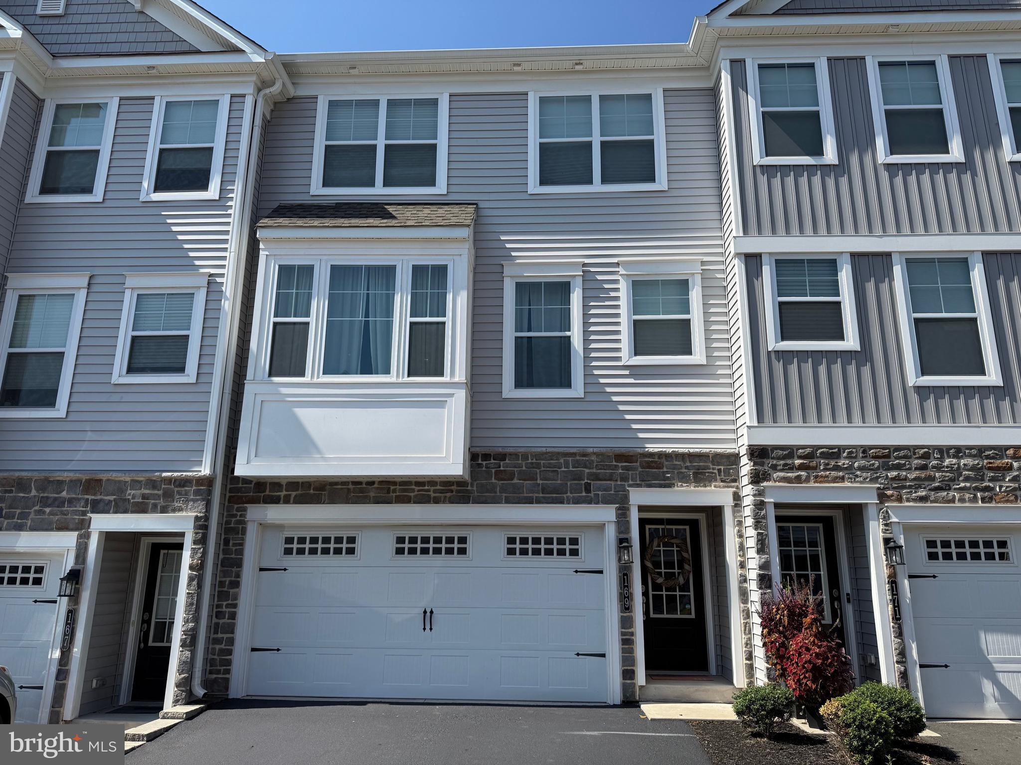 Welcome to 169 Larrabee Way, a beautifully maintained, move-in-ready town home, nestled in the highly sought-after Everleigh Community, which is located in the award-winning Spring-Ford School District! Built in 2021, this residence offers 2,030 square feet of thoughtfully designed living space, featuring 3 bedrooms, 2.5 baths, and tasteful owner-added upgrades that bring extra comfort and convenience. Step inside and take the split foyer stairs up to the open-concept main floor, where the kitchen, dining, and living areas flow together seamlessly, ideal for both everyday living and entertaining. The chef’s kitchen is complete with granite countertops, natural gas range, a spacious island, breakfast bar seating, and stylish cabinetry. Sliding glass doors lead to a private deck—perfect for morning coffee or evening relaxation. The inviting living area showcases a gas fireplace framed by abundant natural light. A well-placed powder room at the stair landing adds practicality without interrupting the open design. Upstairs, you’ll find a full hall bath with tub/shower combo and a convenient laundry closet. The primary suite feels bright and airy with a vaulted ceiling, a custom walk-in closet, and an en-suite bathroom offering dual vanities and a stall shower. Two additional bedrooms complete this level: one with a large window filling the room with sunlight, and another enhanced with a wall of custom closets for exceptional storage. The finished lower level is designed with today’s lifestyle in mind. A dedicated home office area sits alongside a mudroom/storage nook, making it easy to balance work and home life. From here you’ll also find the walkout access and the entrance to the oversized two-car garage. This property’s location is hard to beat. Just a short walk away, Limerick Community Park offers wide open green space, walking trails, newly installed pickleball courts, and the astounding Manderach Memorial Playground. Downtown Royersford is minutes away, where you’ll enjoy local favorites such as Downtown Gastropub, Stickman Brews, and Spring-Ford Diner. For shopping, dining, and entertainment, Philadelphia Premium Outlets and Providence Town Center are only a quick drive. Outdoor enthusiasts will love proximity to the Schuylkill River Trail and Valley Forge National Park, while commuters appreciate easy access to Routes 422, 100, 73 and 29. Schedule a showing today at 169 Larrabee Way and check it out before its gone!
