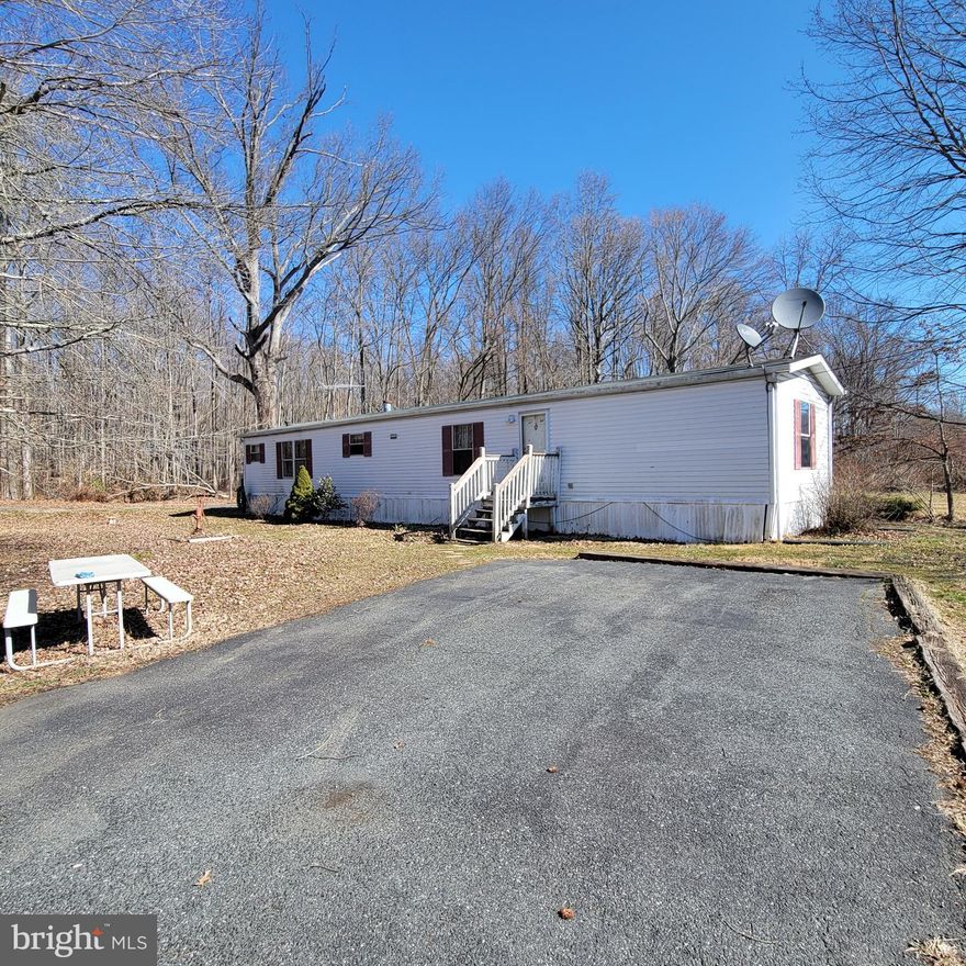 1/2 acre lot improved by a 2 bedroom mobile home. Detached garage, property served by well and holding tanks. Make a great rental. Confirm with health department ability to replace existing mobile home or possibly build. Sold "as-is". Conventional or cash financing only.